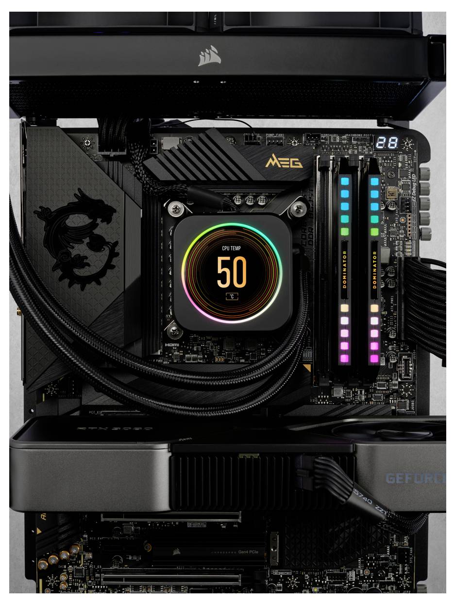 Płyta główna komputera z podświetlonym radiatorem procesora i modułami RAM z podświetleniem RGB. Wskaźnik temperatury procesora wyświetla '50'. Na tle widoczny jest moduł karty graficznej.
