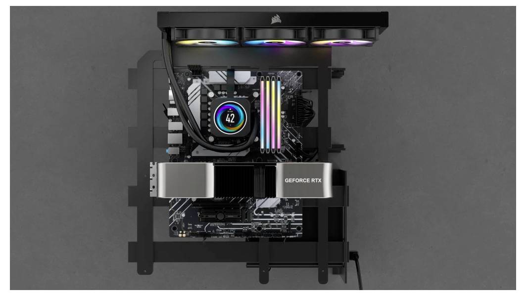 Otwarty komputer prezentuje płytę główną z kartą graficzną 'GeForce RTX' oraz podświetloną pamięcią RAM. Na górze widoczne są podświetlane wentylatory.