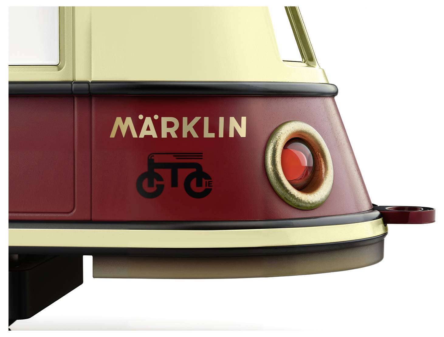 Zbliżenie czerwono-żółtego modelu pociągu Märklin z stylizowanym symbolem roweru i czerwonym okrągłym detalem z boku.