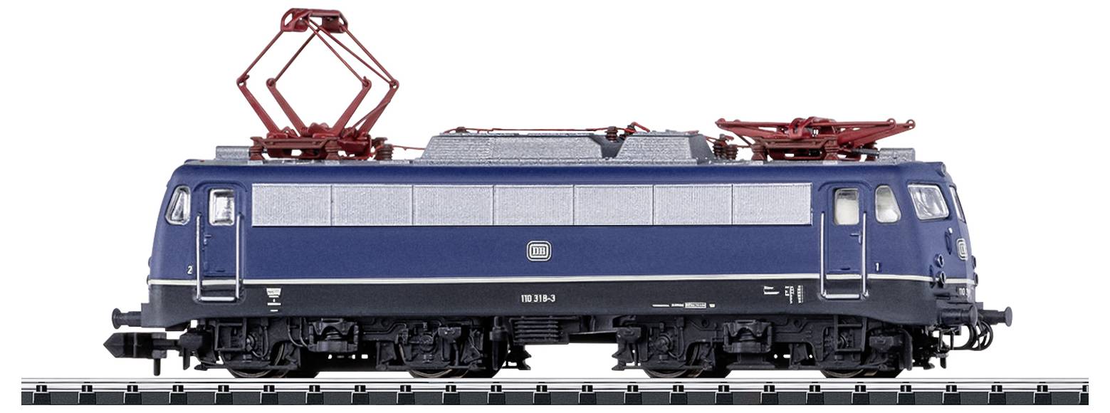 Niebieska lokomotywa modelarska stoi bokiem na torach. Na dachu posiada czerwone pantografy.