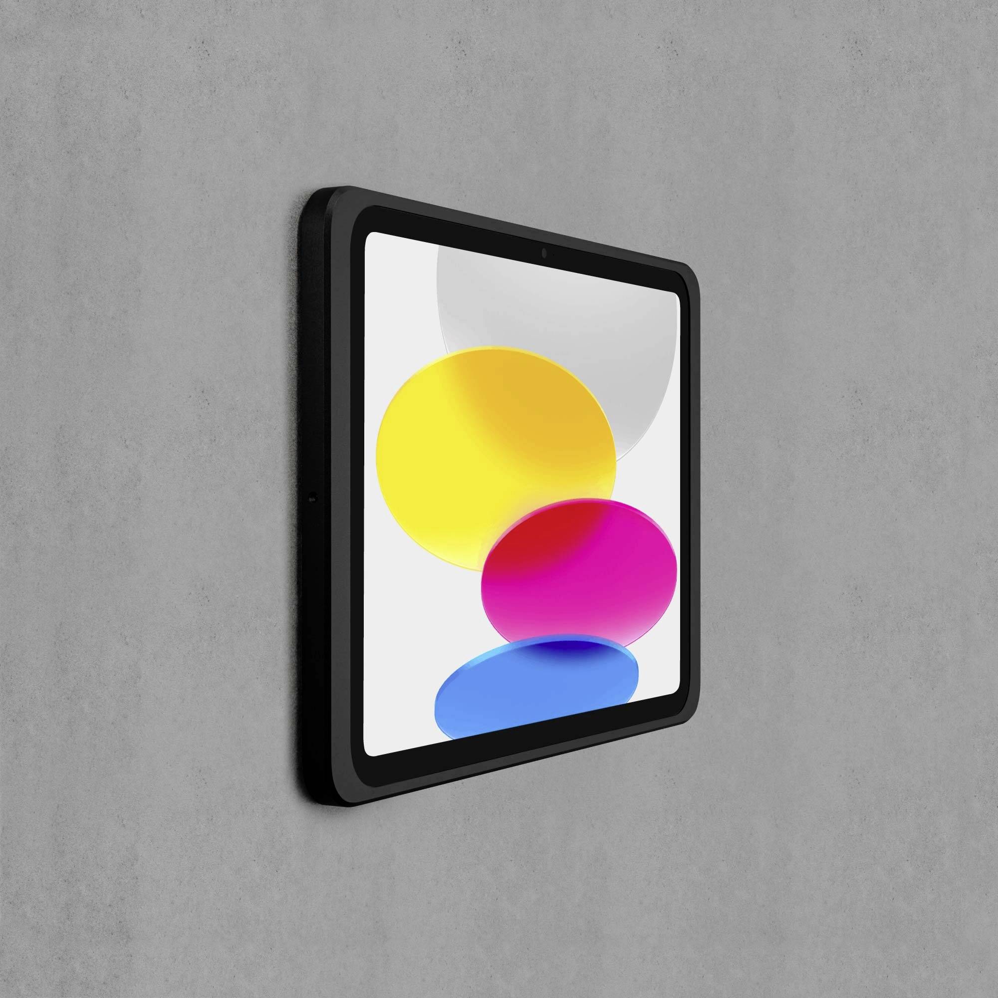 Tablet z czarną ramką pokazuje trzy kolorowe kręgi: żółty, różowy i niebieski, na szarym tle.