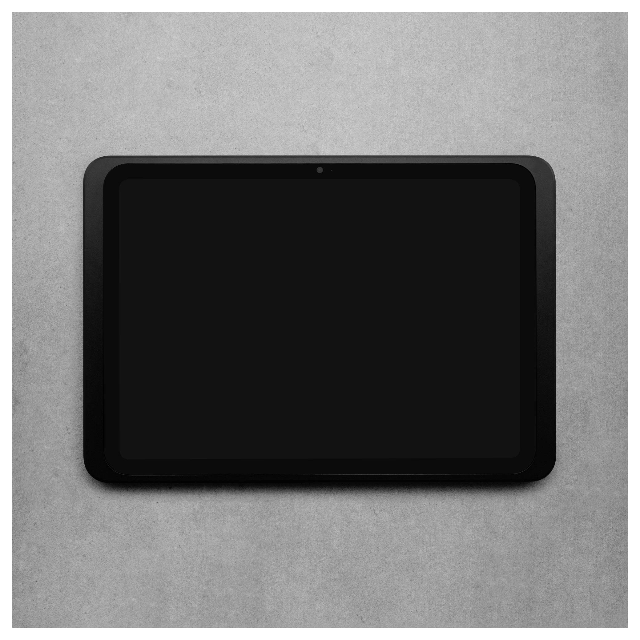 Czarny, wyłączony tablet z ciemnym ekranem, umieszczony centralnie na szarej powierzchni.
