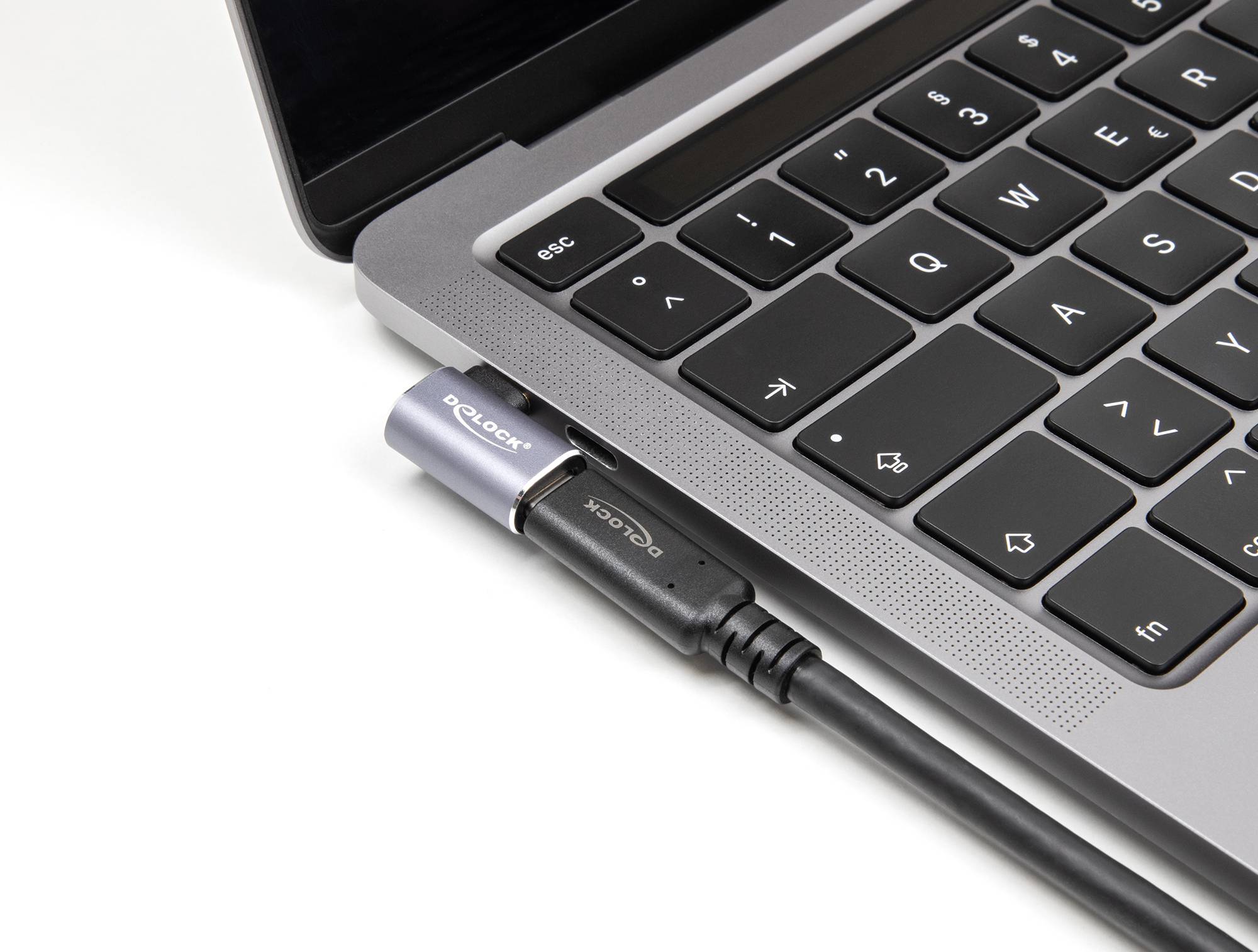 Laptop z czarną klawiaturą; wtyczka USB jest podłączona do jednego z portów.