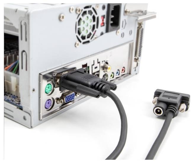 Tylna część komputera z podłączonymi i niepodłączonymi kablami, przedstawiająca różne porty przyłączeniowe i typy przewodów.