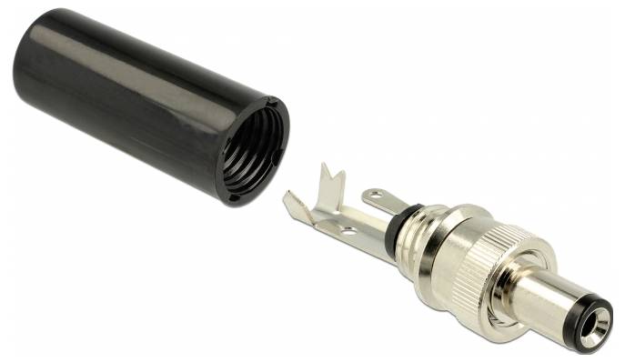 Czarny, cylindryczny adapter i srebrny złącz z otwartym wejściem leżą obok siebie na białej powierzchni.