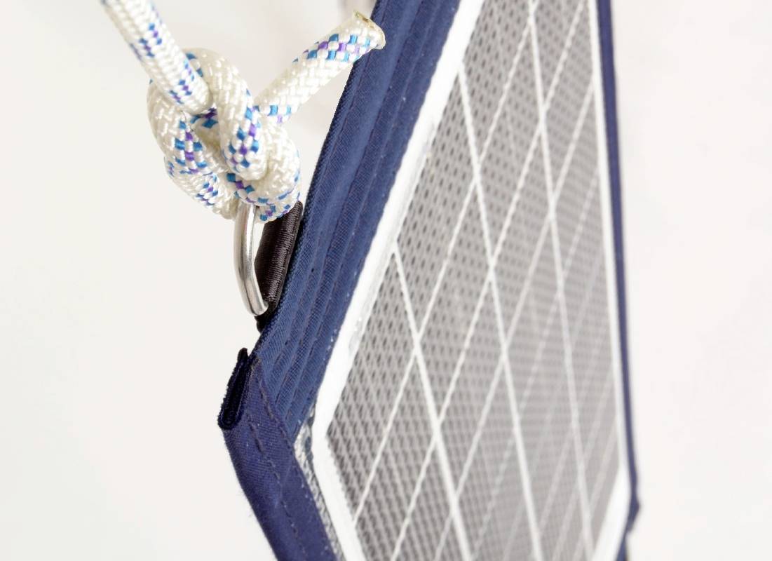 Skośnie umieszczony prostokątny żagiel z tkaniny zamocowany węzłem. Głównie biały i niebieski, w świetle dziennym.