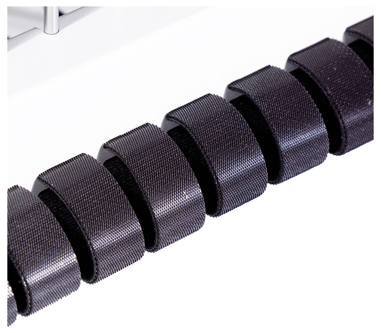 Kilka czarnych, cylindrycznych rolek wykonanych z tworzywa sztucznego lub gumy jest zamontowanych w rzędzie na pręcie.