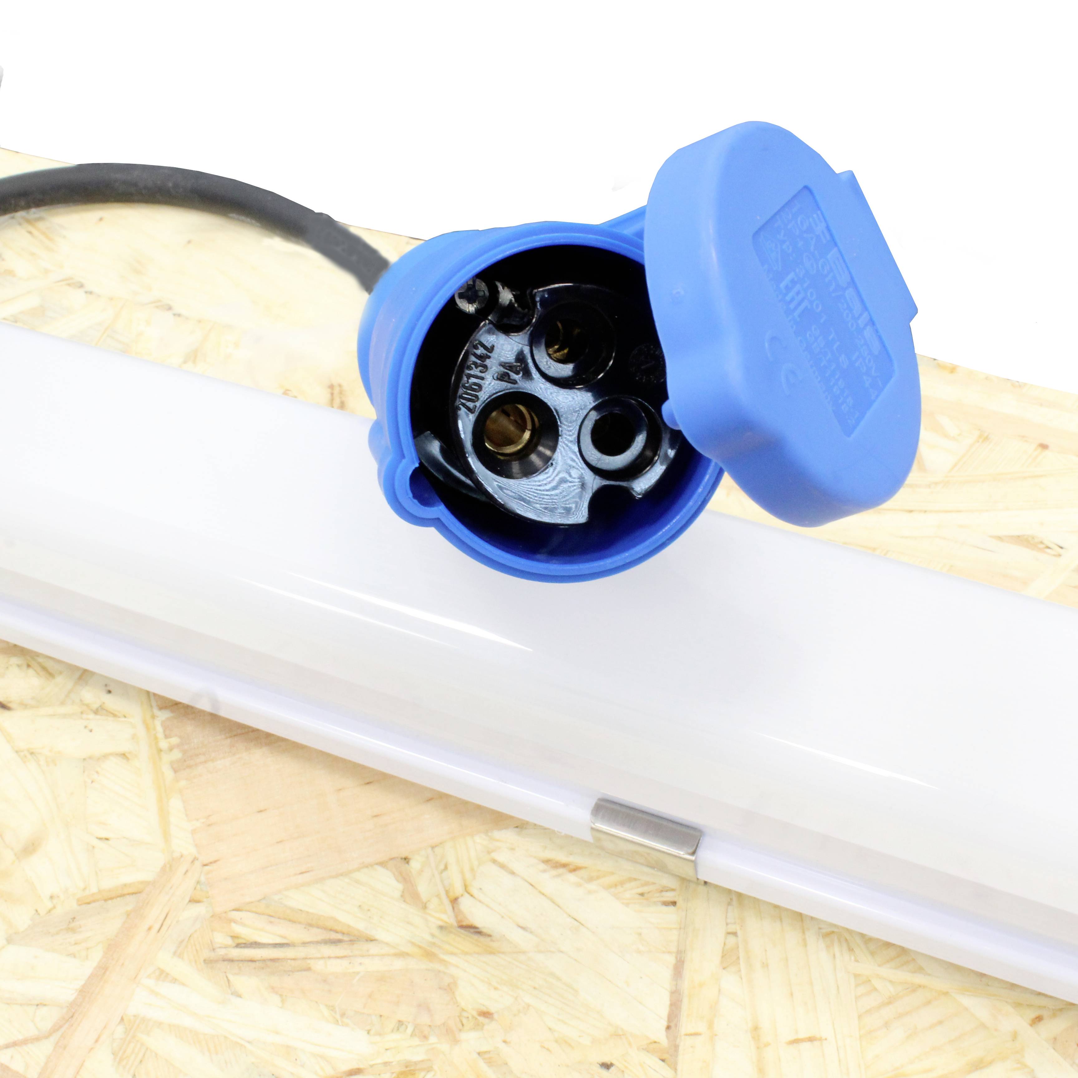 Niebieskie złącze i biała świetlówka na drewnianej powierzchni.