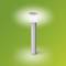 Nowoczesna, stojąca lampa zewnętrzna z cylindryczną podstawą ze stali nierdzewnej i okrągłym, świecącym kloszem na zielonym tle.