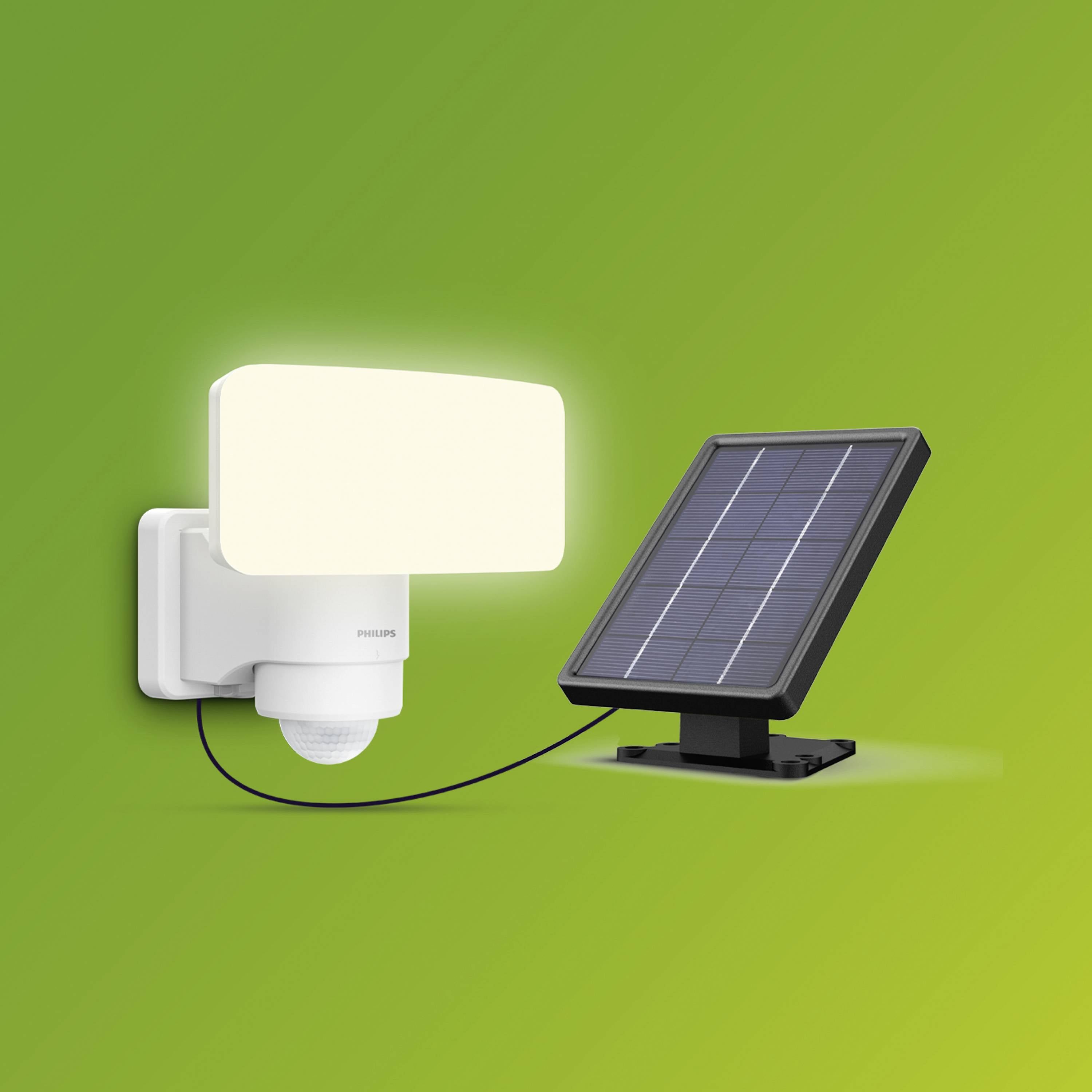 Solarna lampa LED naścienna z czujnikiem, podłączona do panelu słonecznego na zielonym tle. Idealna do zrównoważonego oświetlenia zewnętrznego.