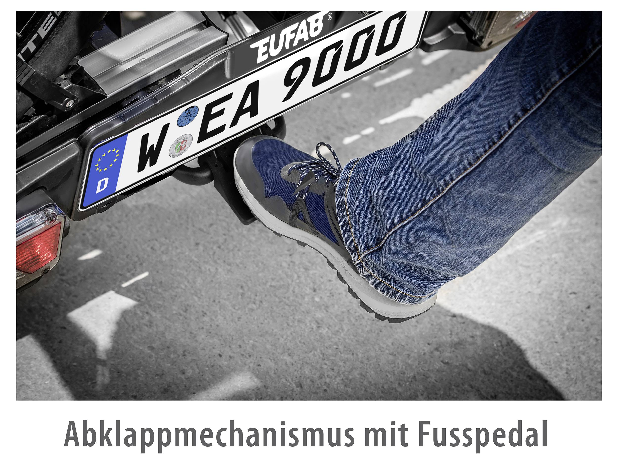 Osoba obsługuje pedał mechanizmu składania w pojeździe prawą stopą. Numer rejestracyjny: W EA 9000.