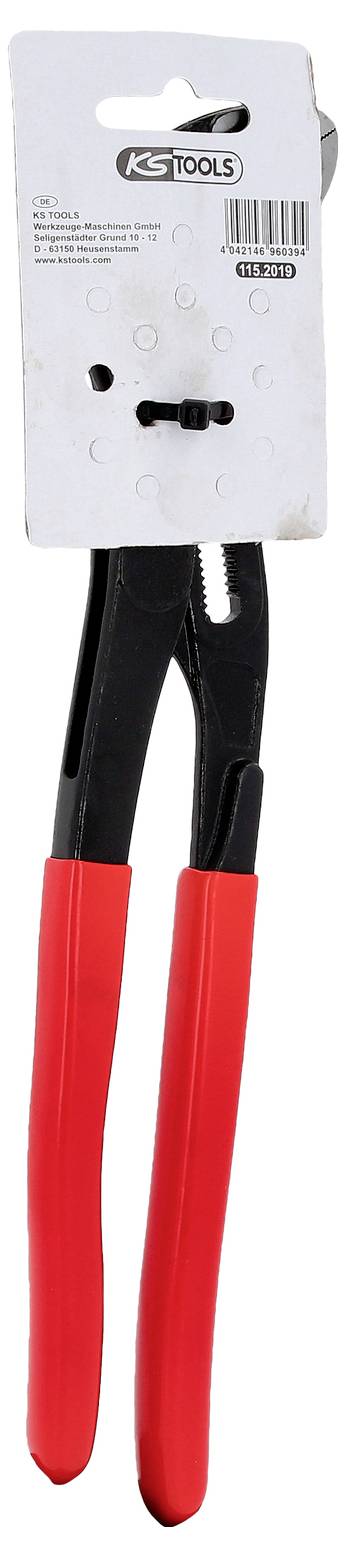 Szczypce do rur o czerwonych uchwytach firmy KS Tools wiszą na karcie opakowaniowej. Narzędzie posiada regulowane szczęki dostosowane do różnych rozmiarów.