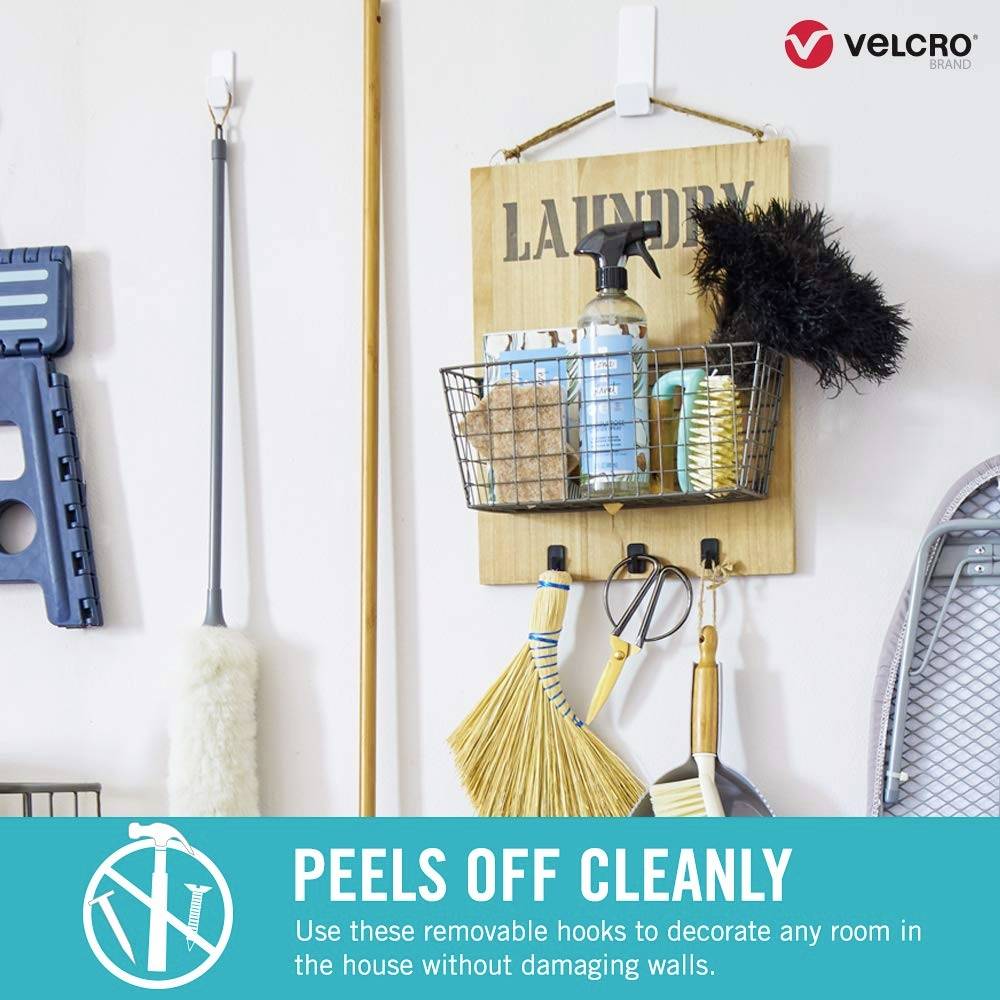 'PRALNIA' napis na ścianie, pod spodem kosz z produktami czystościowymi. Tekst na dole: 'ŁATWO ZDEJMUJE SIĘ - użyj tych zdejmowanych haczyków...'