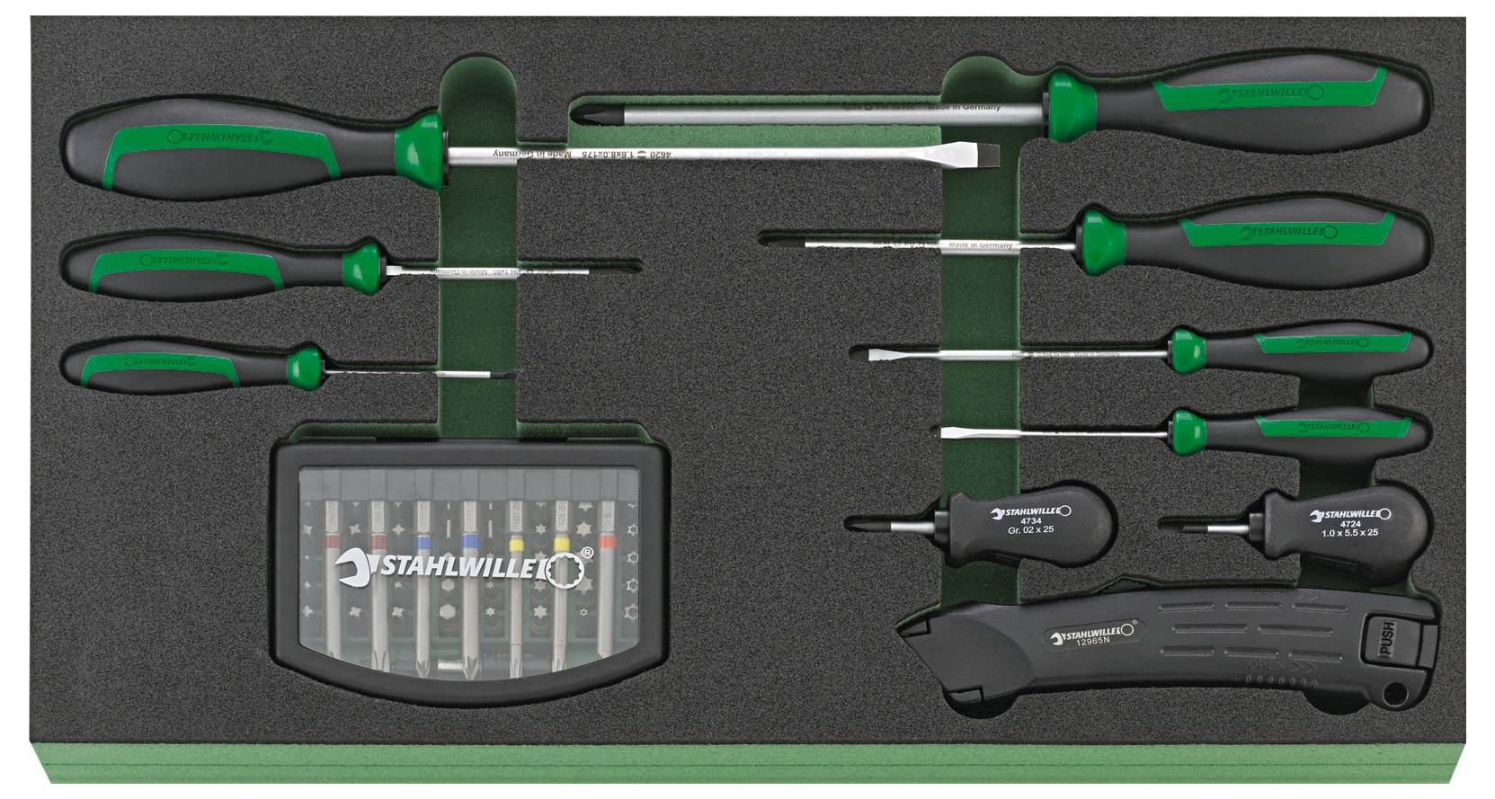 Zestaw narzędzi składający się z kilku śrubokrętów, noża do cięcia oraz zestawu bitów, umieszczonych w wkładce z pianki, wszystkie z zielonymi uchwytami.