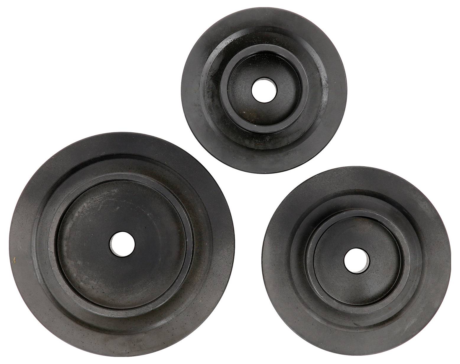 Trzy czarne gumowe krążki z centralnymi otworami leżą obok siebie; są różnej wielkości i ułożone w kształcie trójkąta.