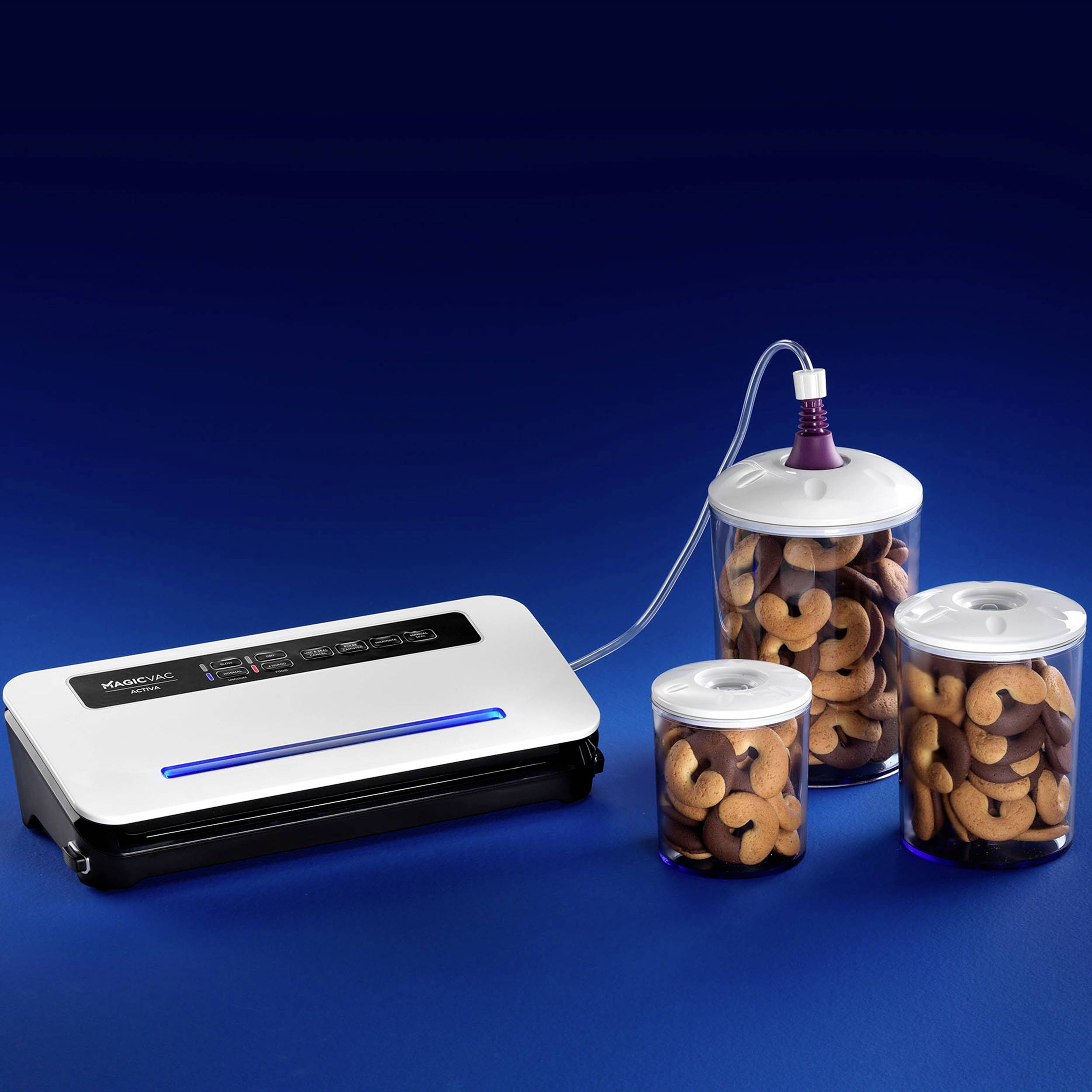 Urządzenie do pakowania próżniowego obok trzech szczelnie zamkniętych pojemników z orzechami nerkowymi na niebieskim tle.