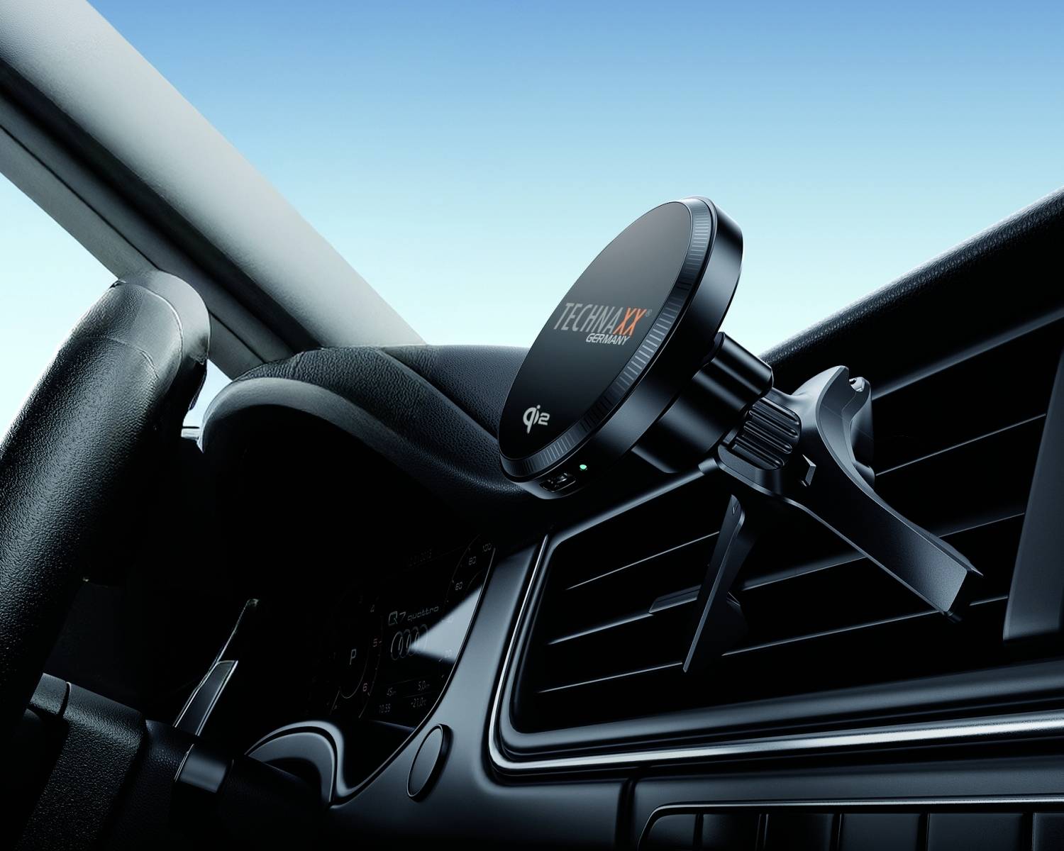 Czarny uchwyt na smartfona jest zamocowany na kratce nawiewu w samochodzie, gotowy do użycia podczas nawigacji lub rozmów głośnomówiących.