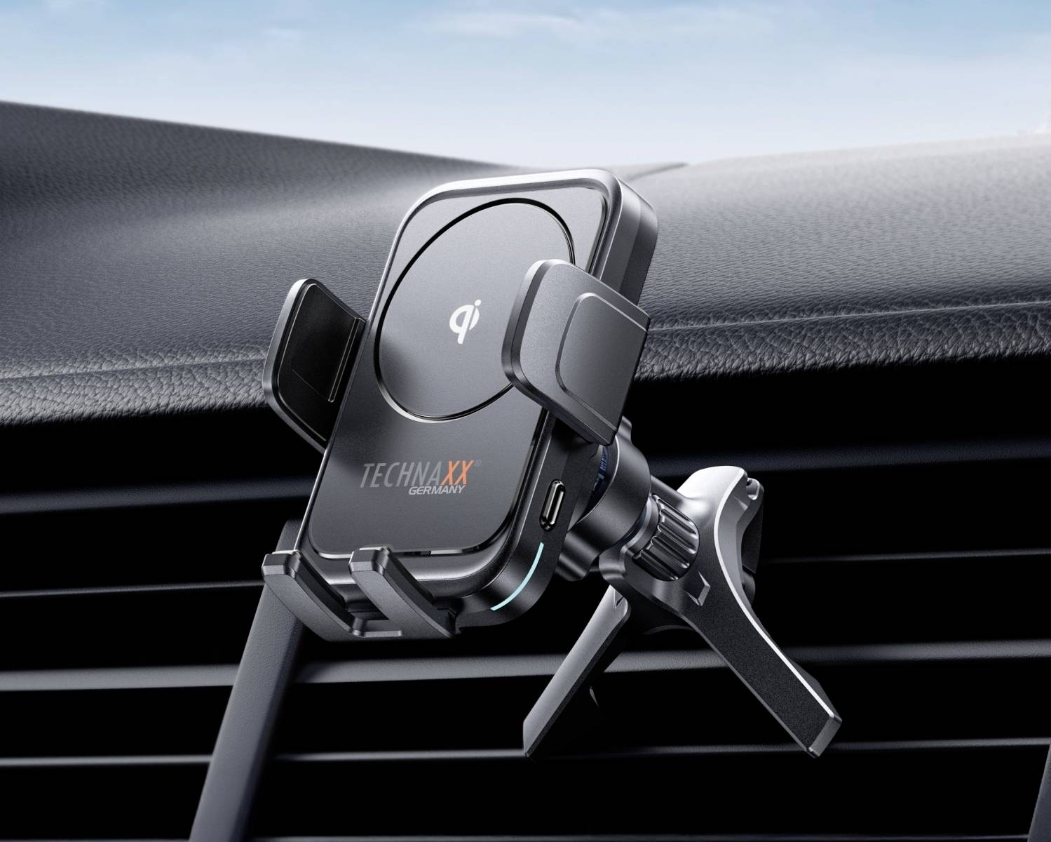 Uniwersalny uchwyt na smartfona z funkcją ładowania bezprzewodowego jest zamocowany na kratce nawiewu w samochodzie.