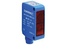 Niebieski czujnik optoelektroniczny z czerwonym okienkiem świetlnym. Nadruk modelu: 'CONTRINEX'. Stosowany do pomiaru odległości obiektów.