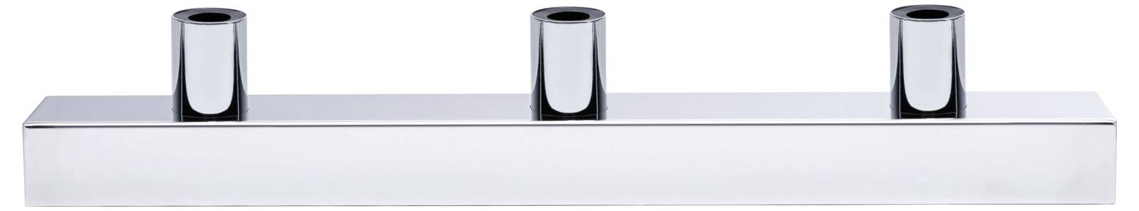 Trójkomorowy świecznik w kolorze chromu z trzema prostymi, cylindrycznymi otworami na świece, umieszczony na prostokątnej podstawie.