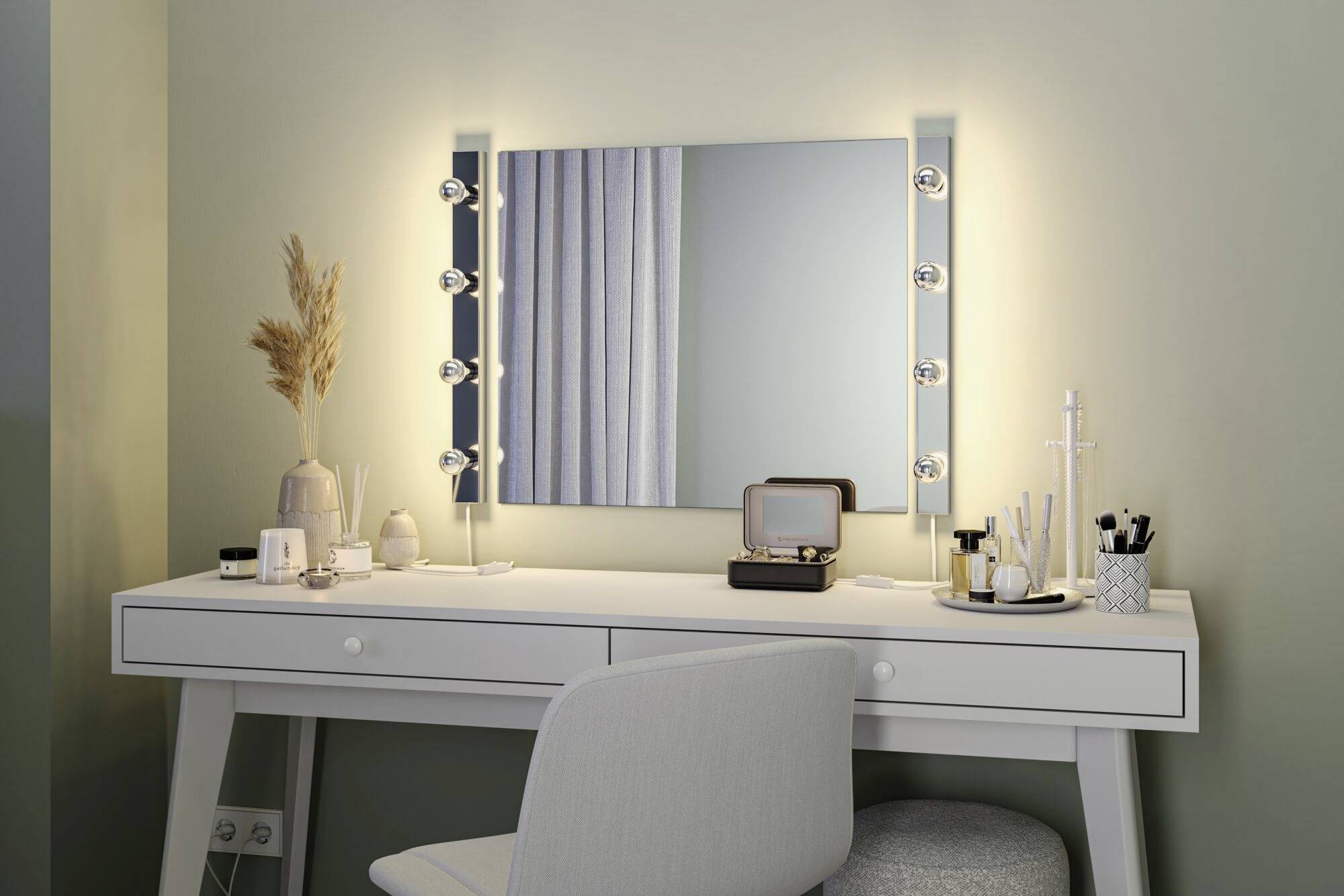 Toaletka z lustrem jest ustawiona w jasnym pomieszczeniu. Na blacie leżą pędzle, kosmetyki, lampa oraz stoi krzesło.