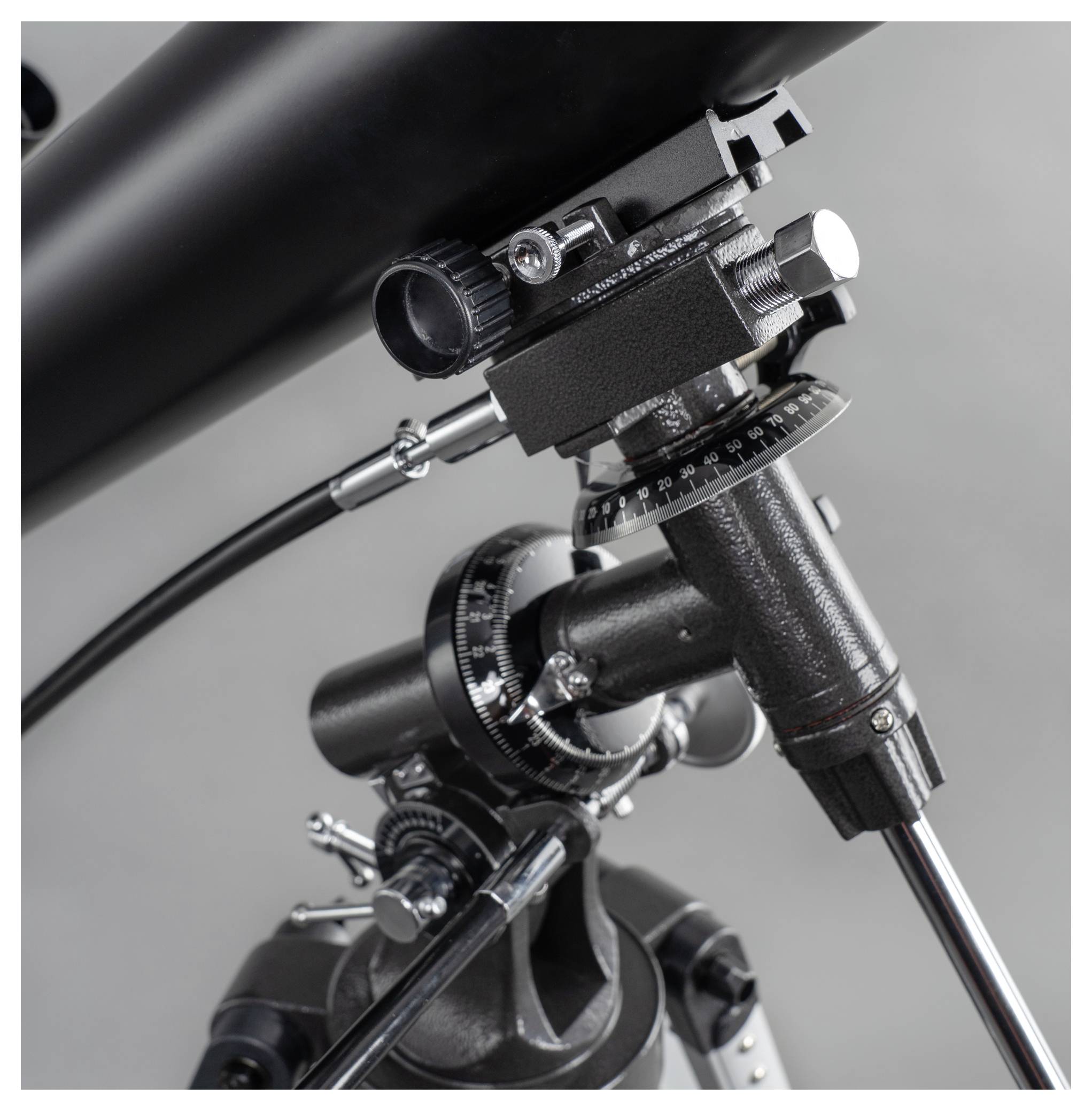 Zbliżenie teleskopu z pokrętłami regulacyjnymi i przyciskami sterującymi, zamocowanego na statywie.