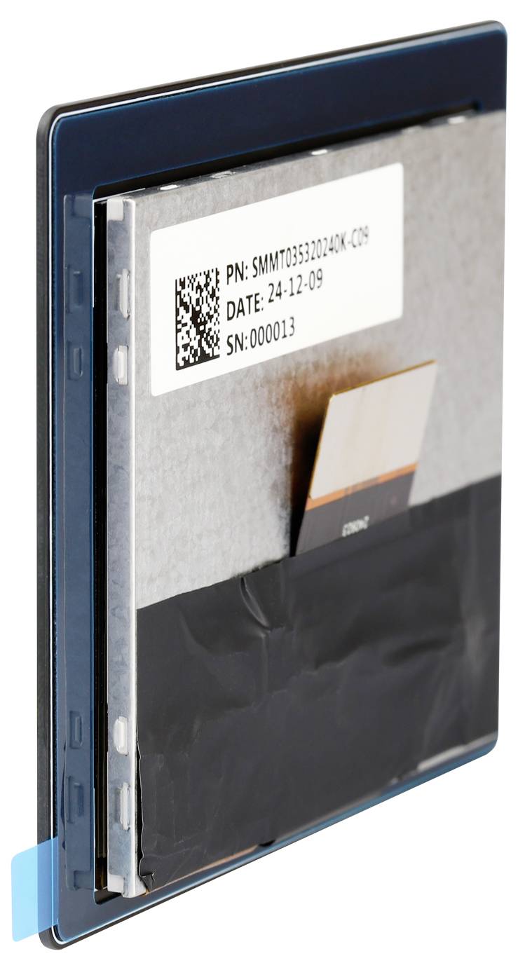 Prostokątne urządzenie elektroniczne ze składnikami metalowymi i plastikowymi. Na naklejce widoczny jest numer produktu, data oraz numer seryjny.