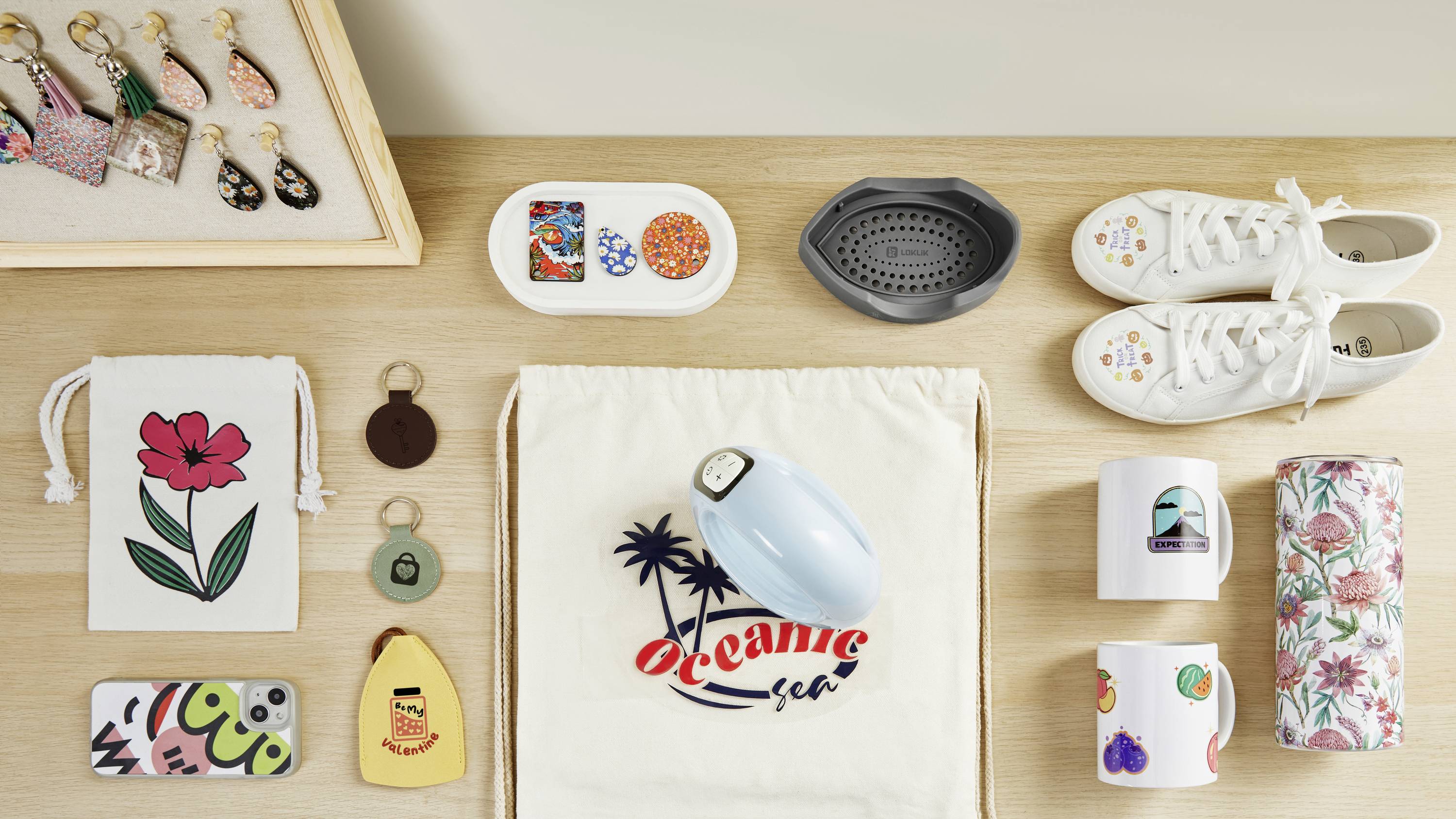 Różne kolorowe akcesoria i elementy garderoby na stole, w tym torby, kubki, breloki, buty i żelazko.