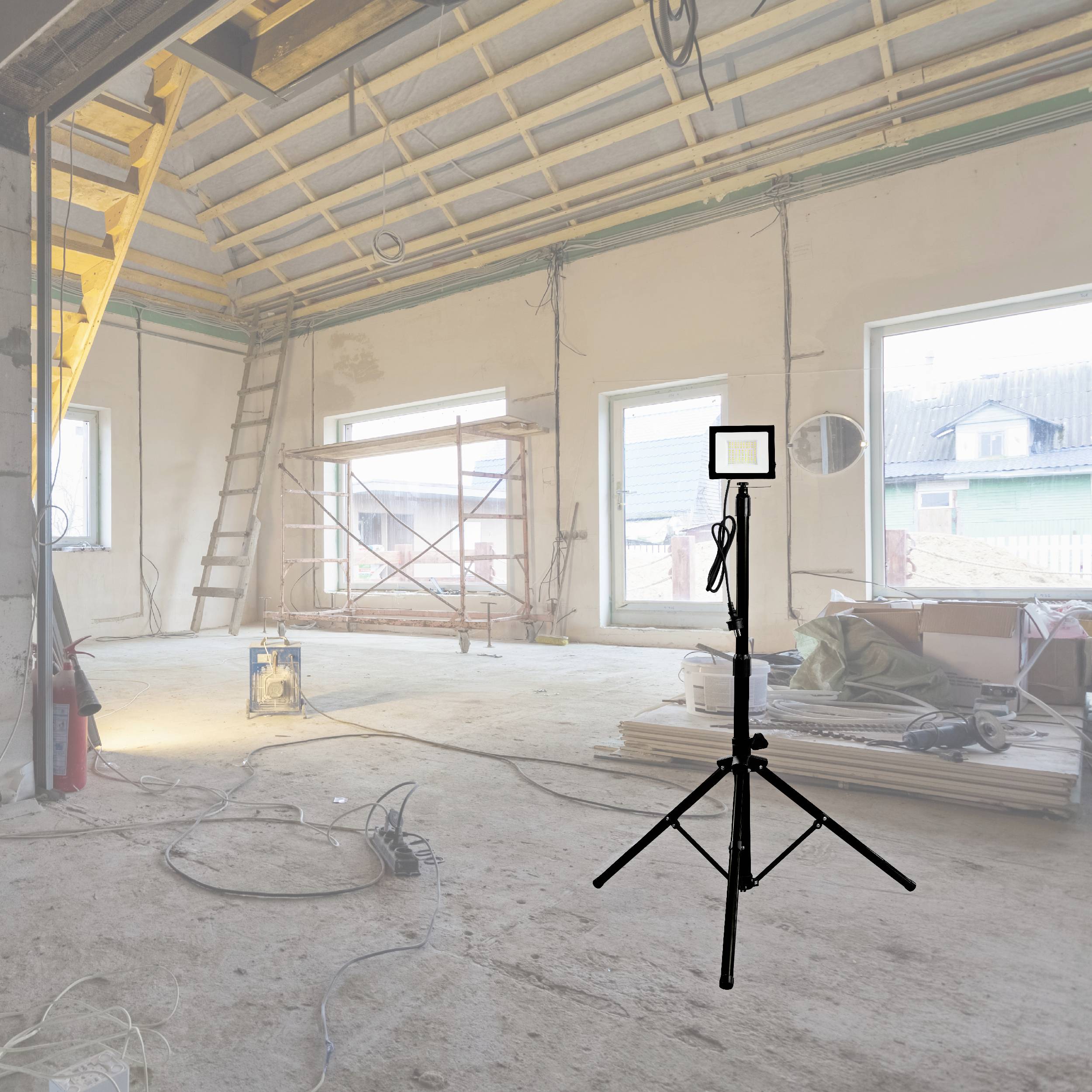 Plac budowy z niedokończoną więźbą dachową. Statyw z lampą budowlaną stoi na pierwszym planie, skierowany, aby oświetlić przestrzeń.