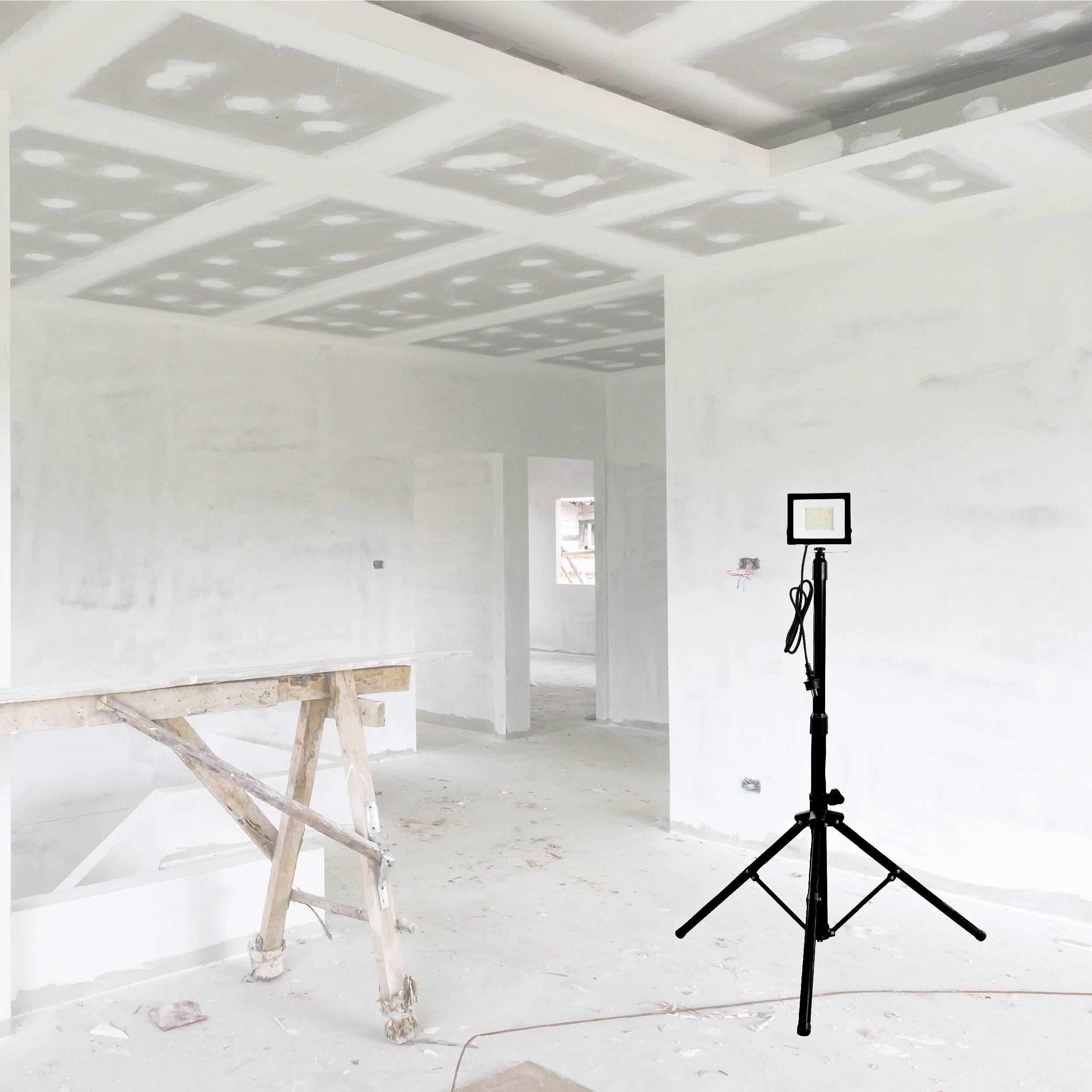 Strefa budowy z malowanymi ścianami i drabiną po lewej stronie. Statyw z lampą pierścieniową stoi centralnie w pomieszczeniu.