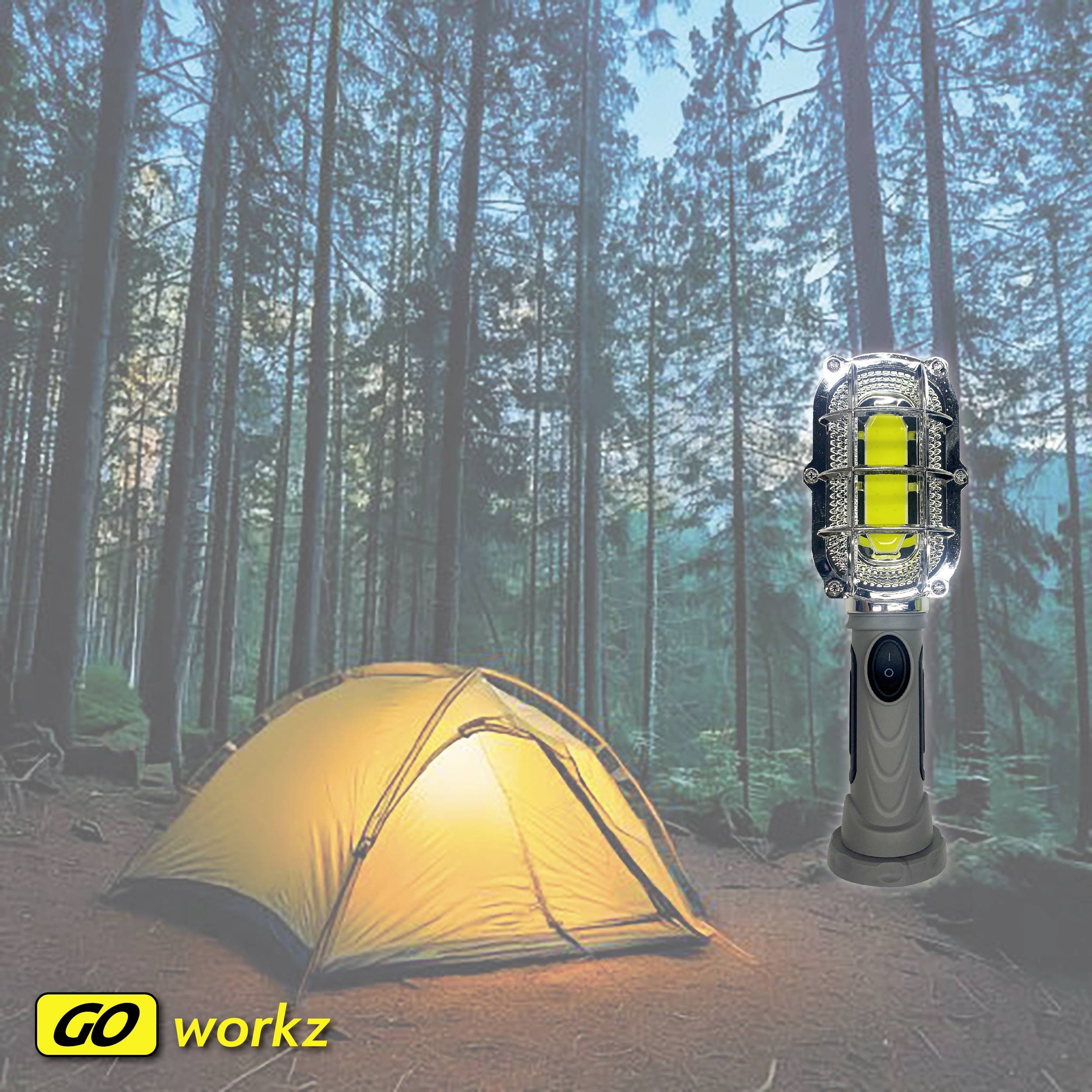 Żółty namiot stoi w lesie o zmierzchu. Obok niego świeci latarnia. W lewym dolnym rogu znajduje się logo 'GO workz'.