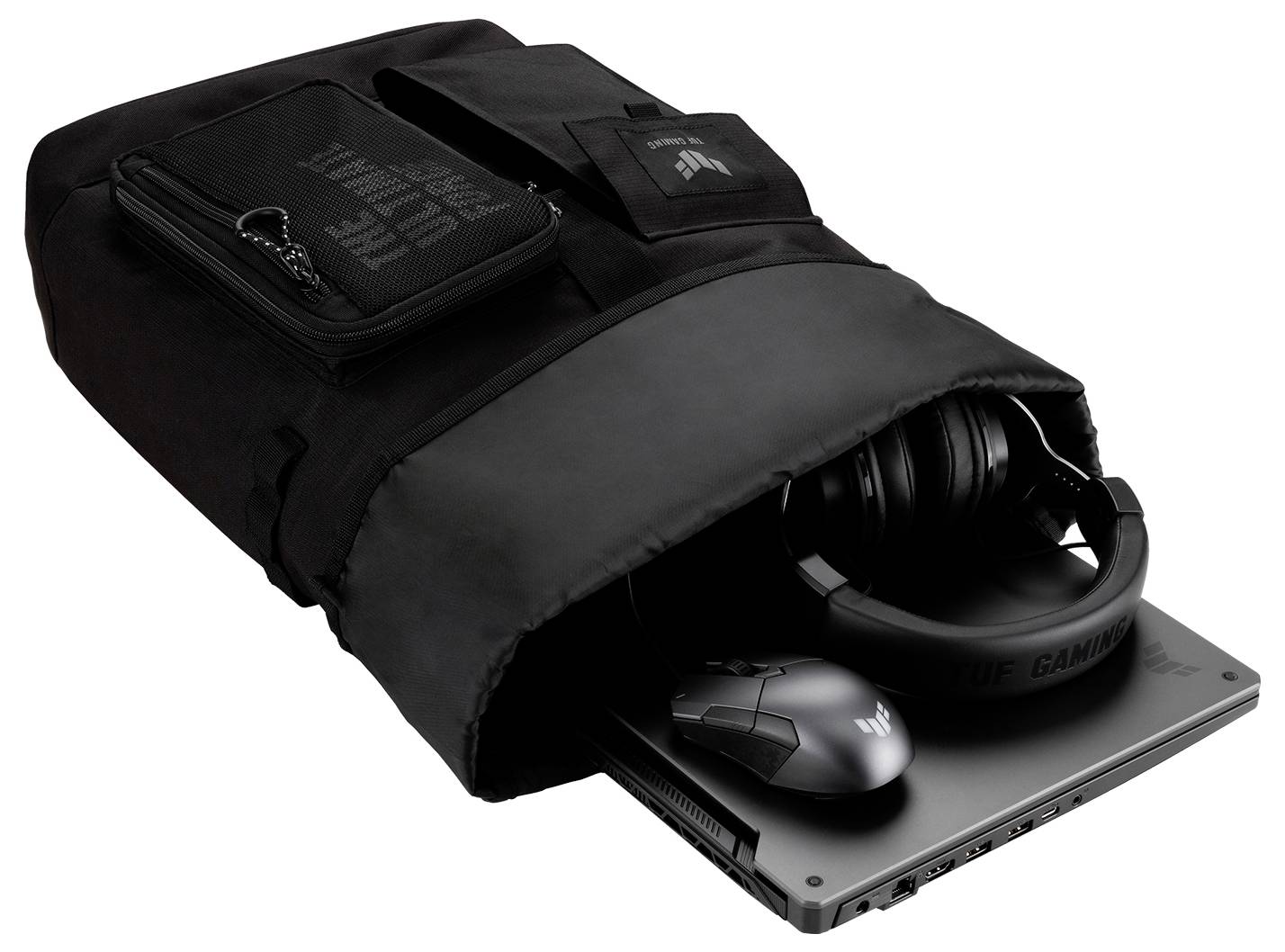 Czarny plecak z laptopem, myszą i słuchawkami, częściowo wyciągniętymi. Idealny do przechowywania sprzętu gamingowego.