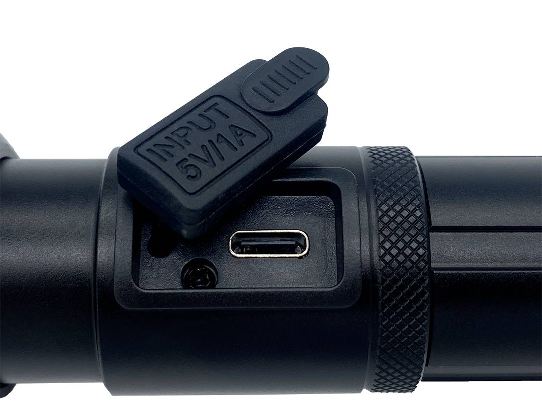 Zbliżenie czarnego złącza urządzenia z zakrytym gniazdem ładowania, na którym widnieje napis 'INPUT 5V1A'.