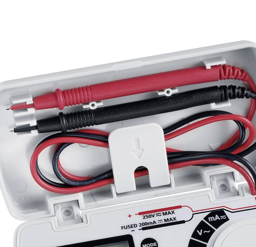 Otwarty korpus multimetru z czerwonymi i czarnymi przewodami pomiarowymi. Kable są zwinięte, a bezpiecznik jest zamontowany.