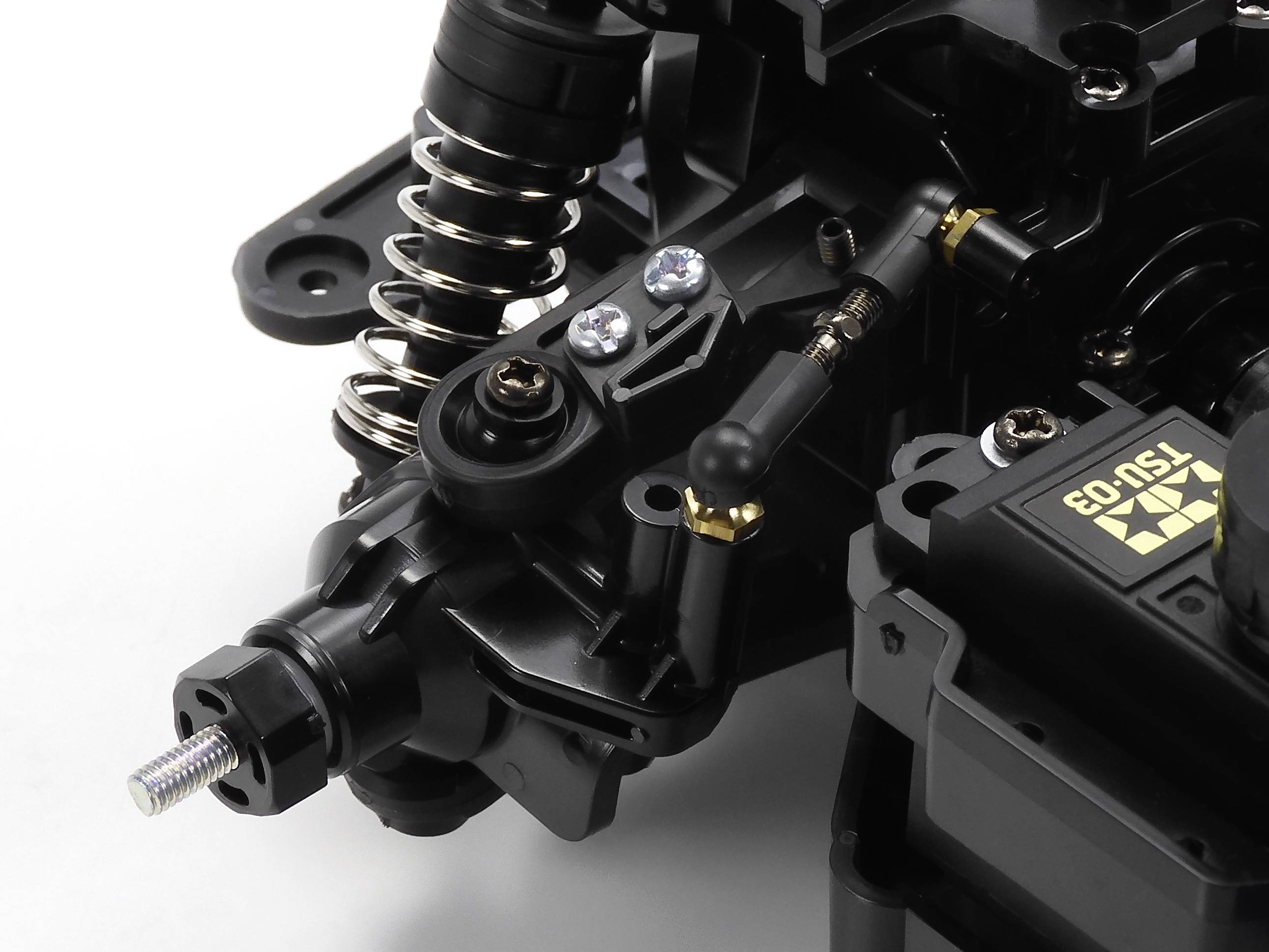 Zbliżenie mechanicznego elementu z sprężynami i przykręcanymi komponentami, prawdopodobnie będącego częścią pojazdu lub urządzenia technicznego.