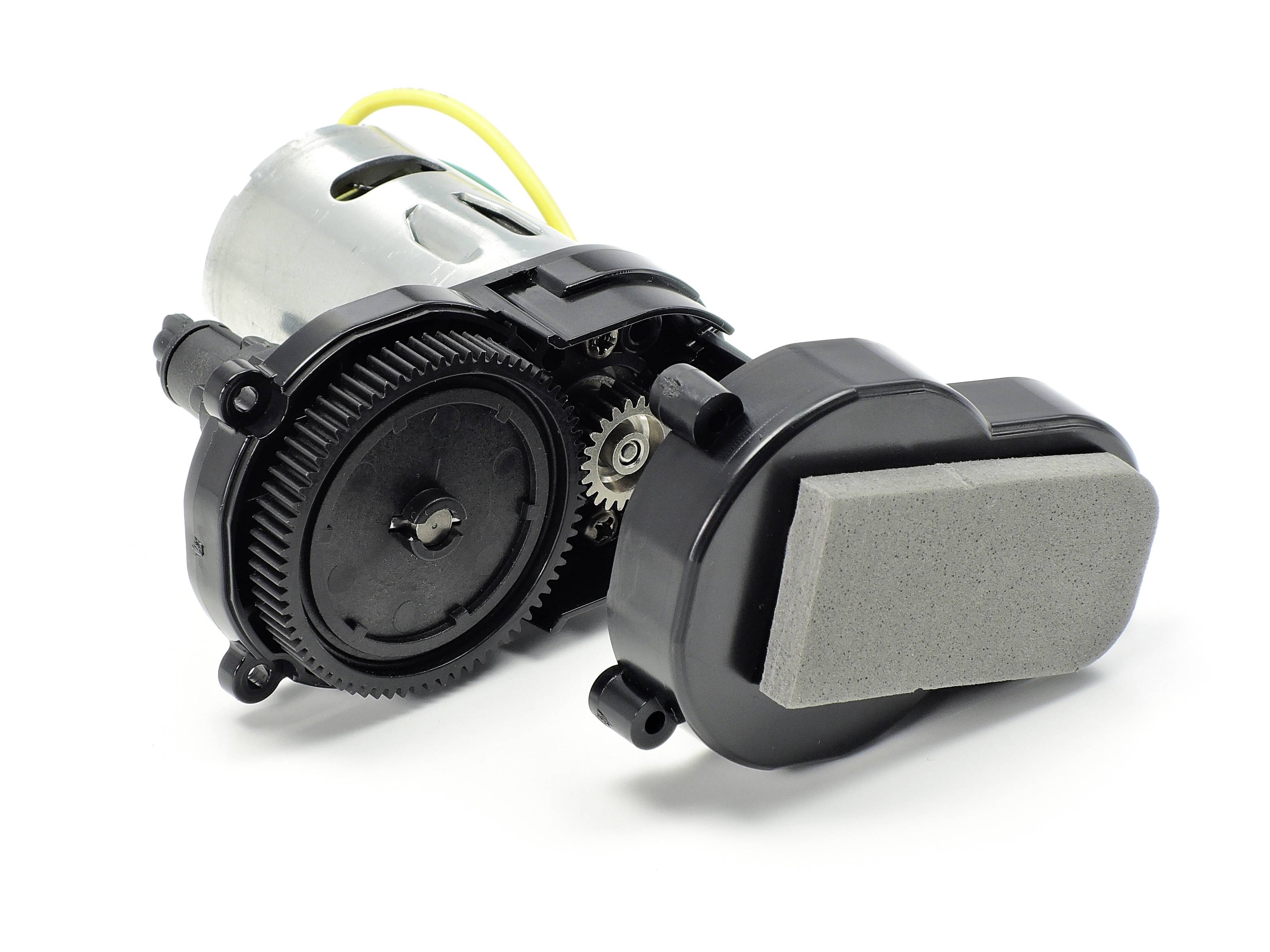 Mały silnik elektryczny z przekładnią zębatą i obudową z tworzywa sztucznego, wyposażony w przewód do zasilania.