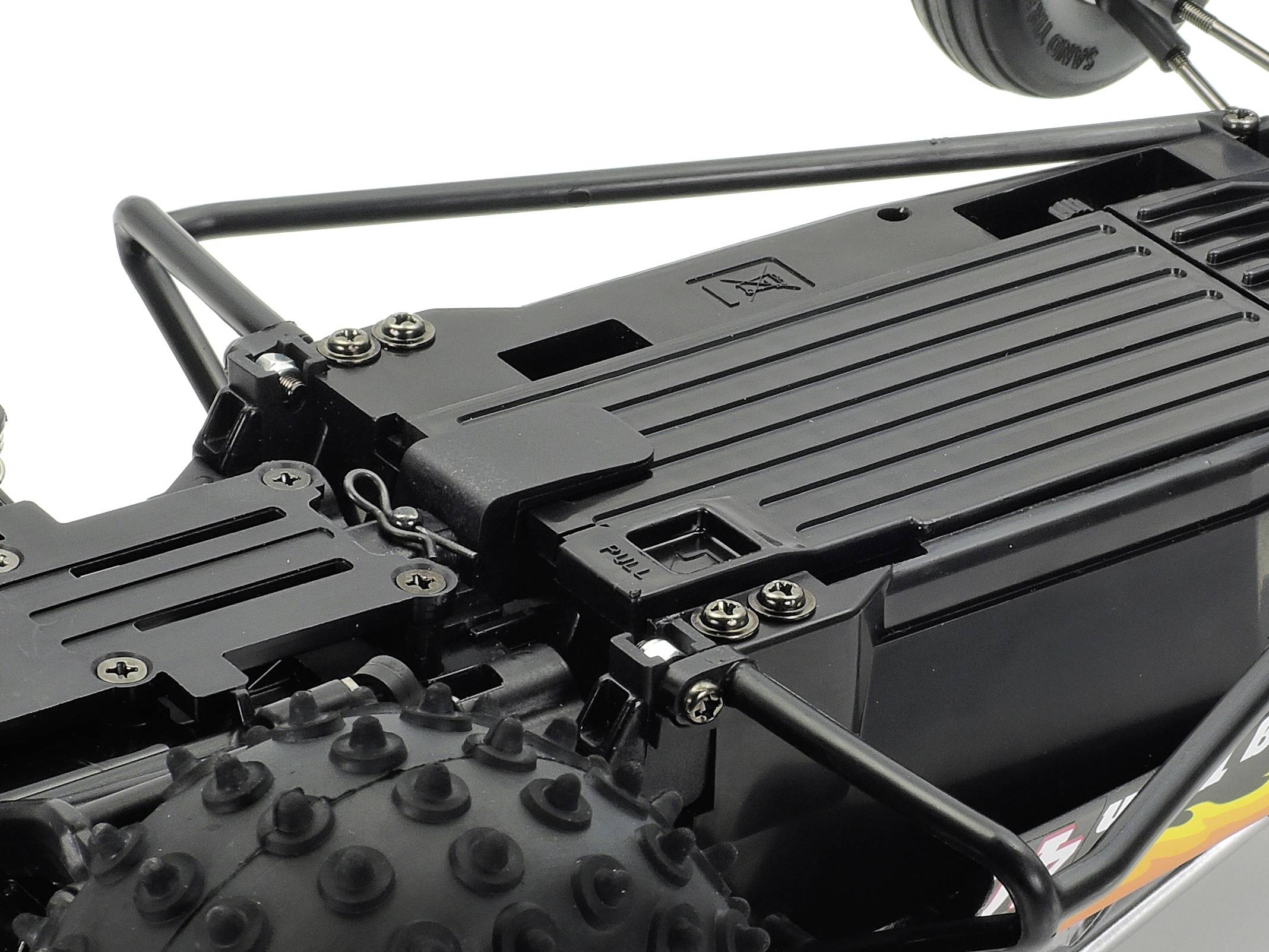 Zbliżenie dachu zdalnie sterowanego pojazdu z widocznymi szczegółami struktury i przymocowanymi kołami.