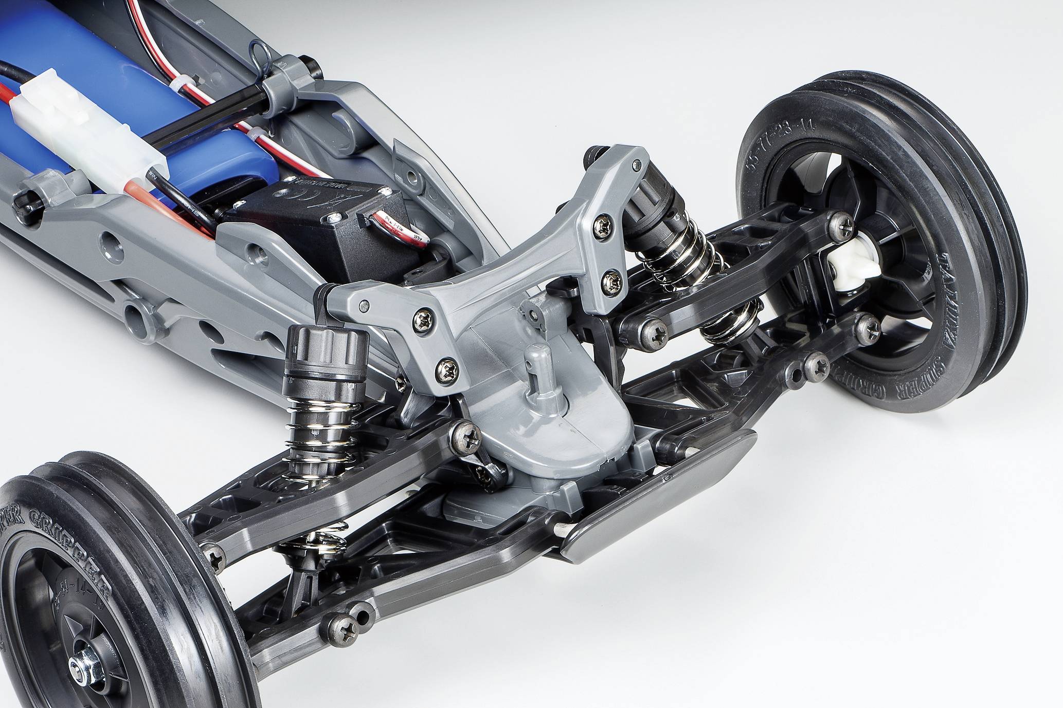 Zbliżenie przedniej ramy samochodu modelowego z amortyzatorami i kołami. Szczegółowy widok mechanizmu i zawieszenia samochodu.