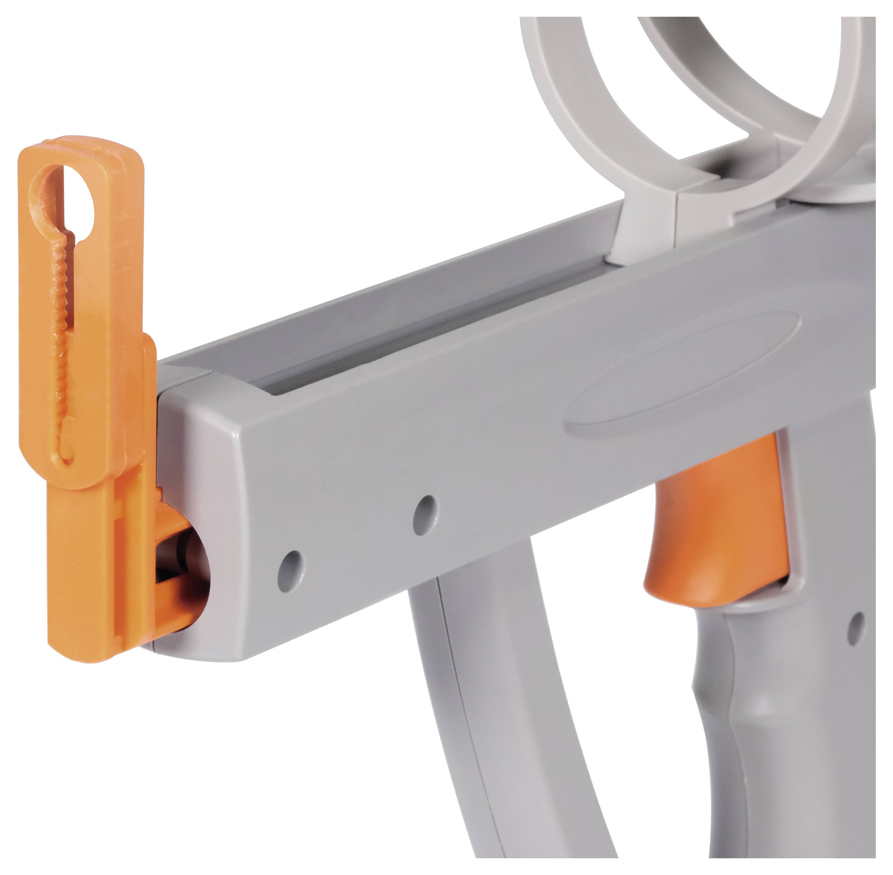 Zbliżenie szarego i pomarańczowego plastikowego przedmiotu z dużym, cylindrycznym otworem u góry. Jego przeznaczenie nie jest oczywiste.