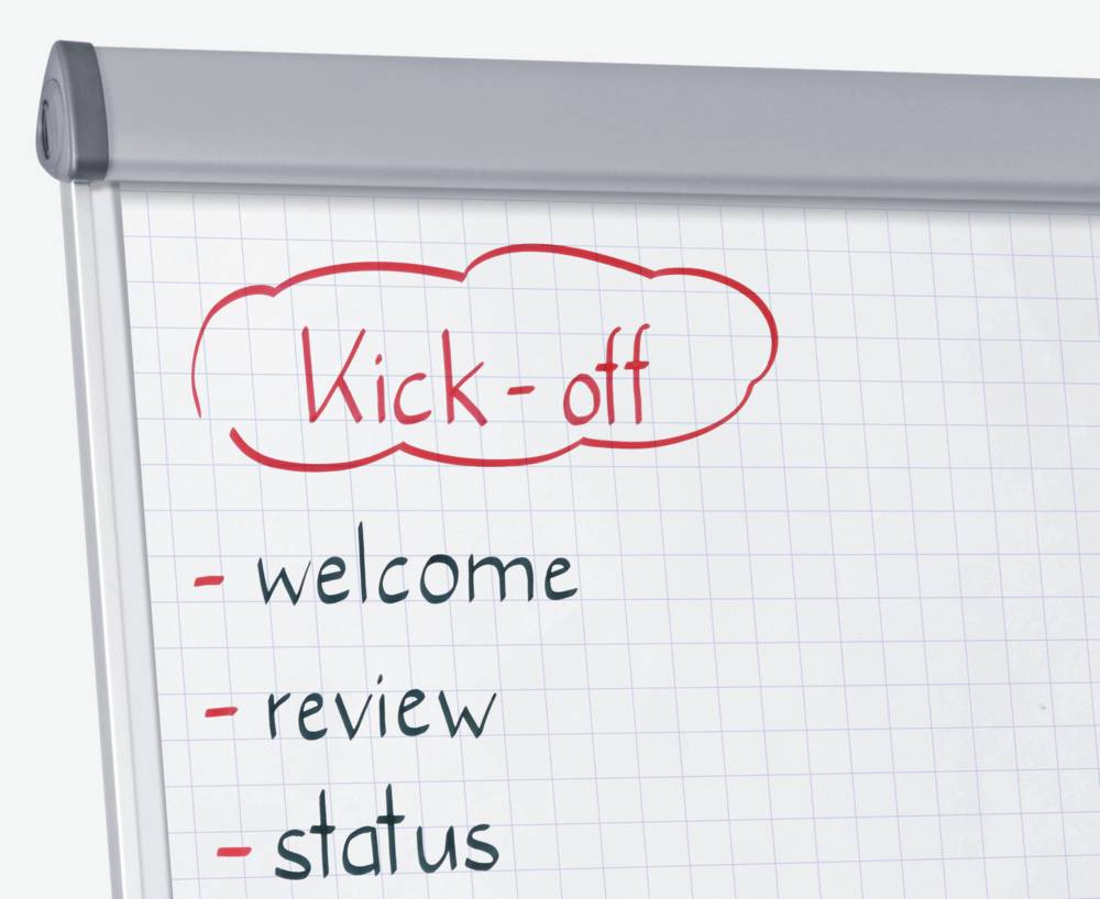 Flipchart z nagłówkiem 'Kick-off'. Poniżej w punktach: powitanie, przegląd, status.