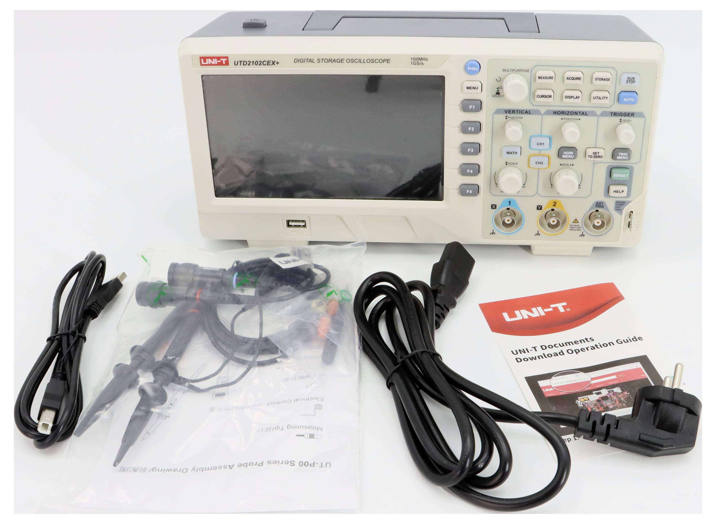 Cyfrowy oscyloskop pamięciowy z wyposażeniem, w tym przewodami pomiarowymi, przewodem zasilającym, instrukcją obsługi oraz materiałami opakowaniowymi.