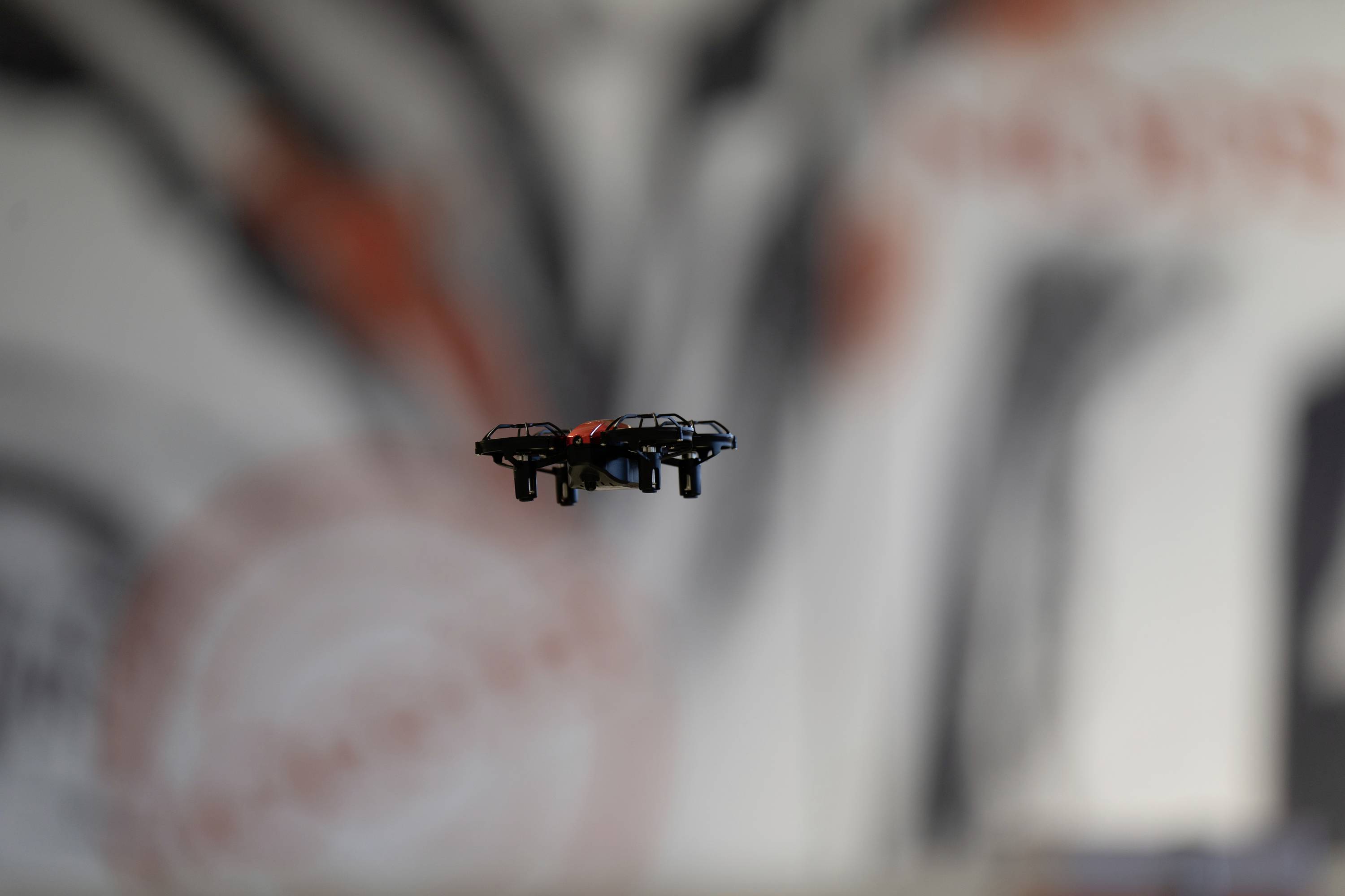 Mała dronka unosi się w rozmytym wnętrzu ozdobnym abstrakcyjnymi dziełami sztuki na ścianach.