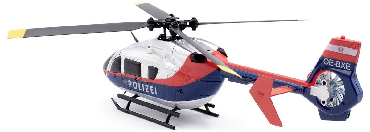 Zabawkowy helikopter policyjny w kolorach niebieskim, czerwonym i białym z napisem 'POLICJA' na boku, stoi na płaskiej powierzchni.