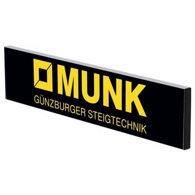 Tabliczka z żółtym logo i tekstem: 'MUNK - Günzburger Technika Podestowa' na czarnym tle. Znak firmowy po lewej stronie obok tekstu.
