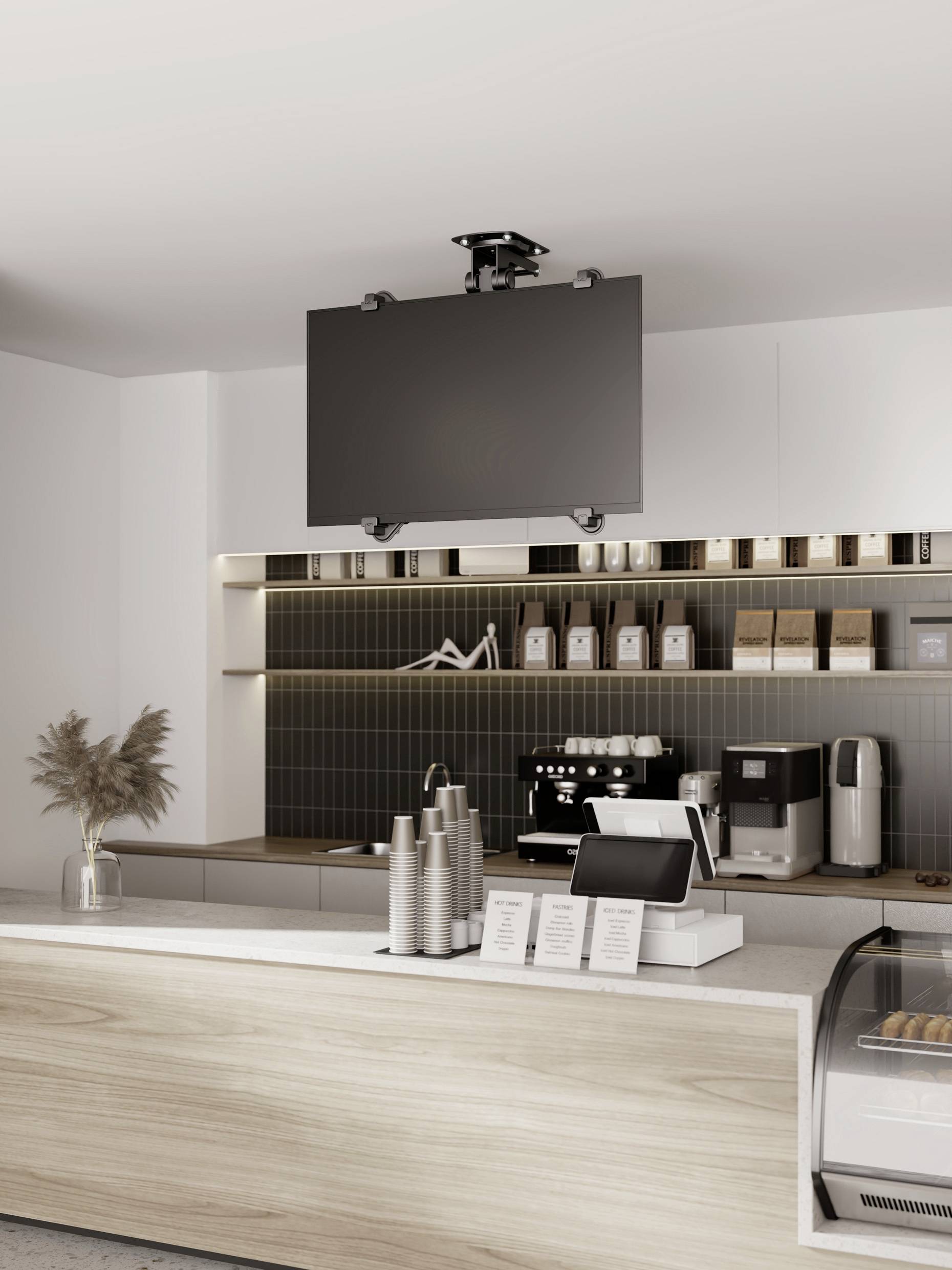 Stylowy kawiarnia z nowoczesnym wyposażeniem, ekspresem do kawy i akcesoriami kawowymi na ladzie. Na suficie wisi ekran.