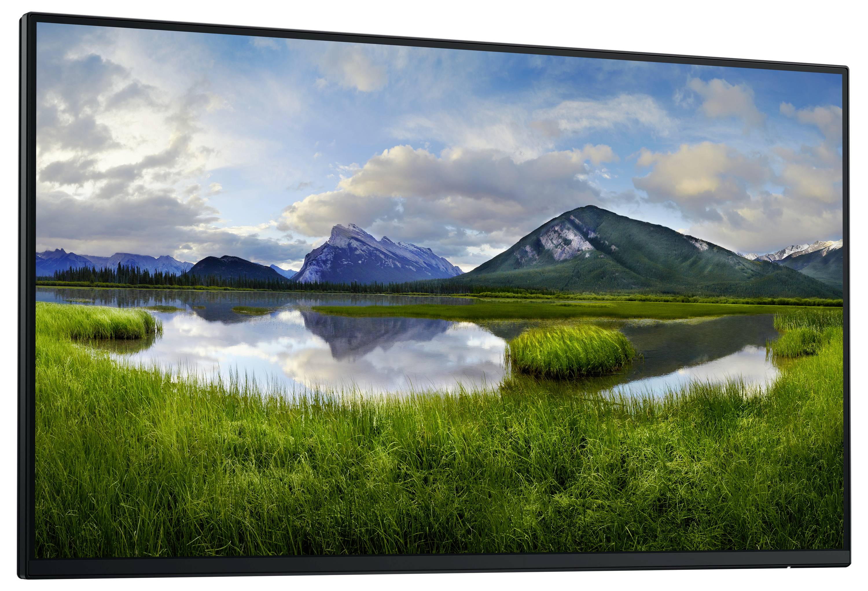 Spokojna panorama krajobrazu z jeziorem otoczonym zielonymi łąkami. Góry i zachmurzone niebo odbijają się w tafli wody.