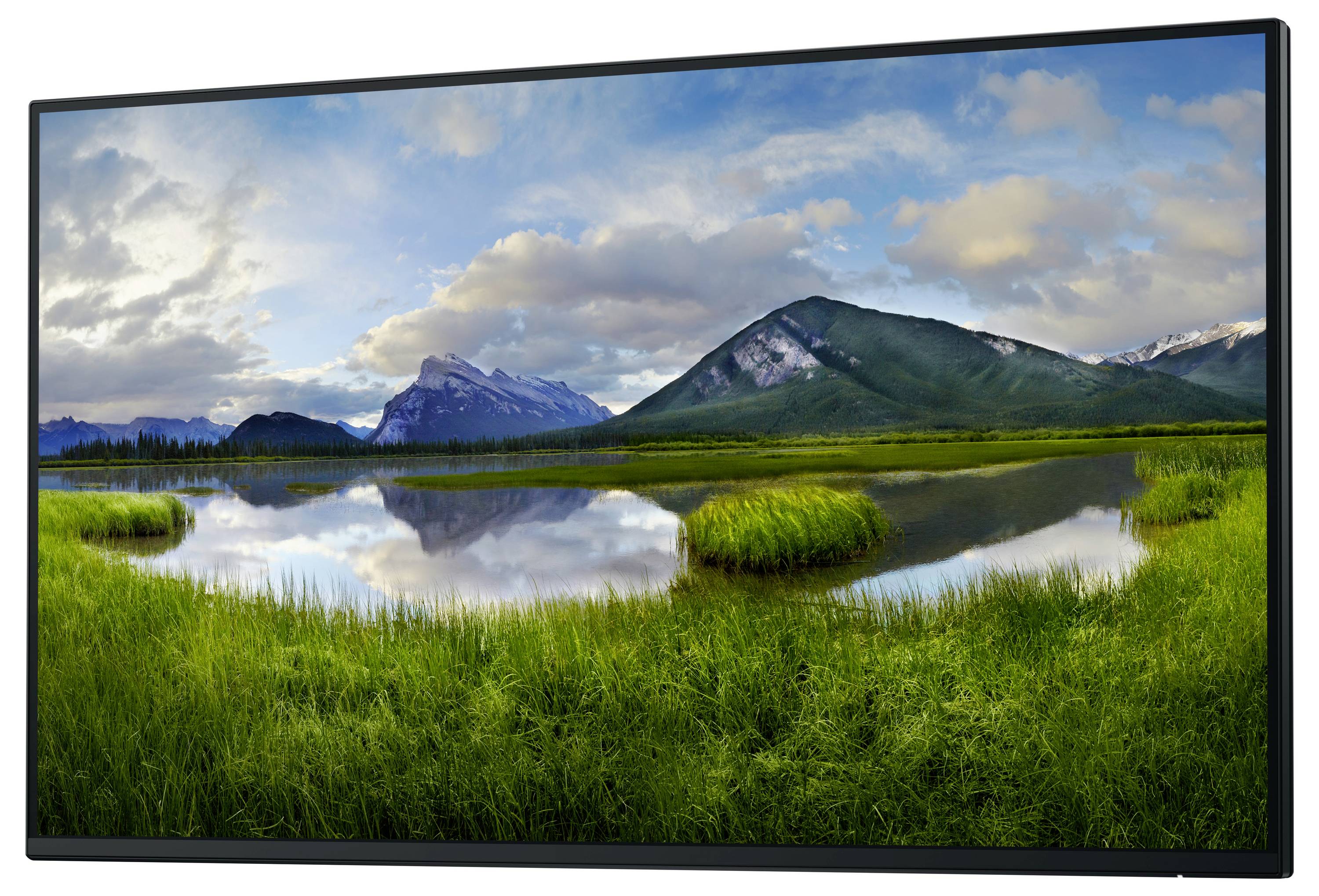 Zdjęcie krajobrazu przedstawiające spokojne jezioro z zielonymi brzegami, otoczone górami pod zachmurzonym niebem.