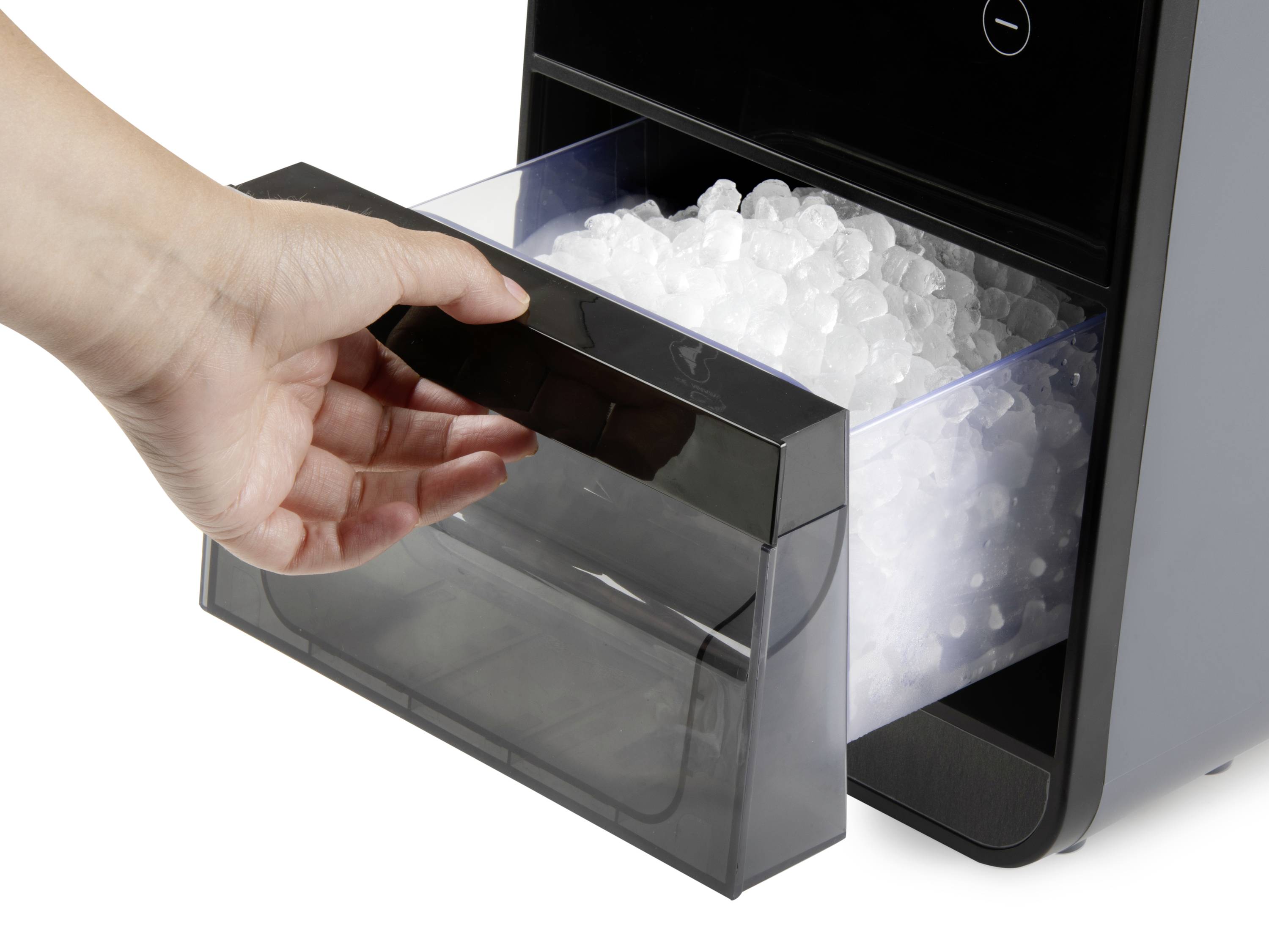 Dłoń otwiera komorę w lodówce i wyjmuje kostki lodu.