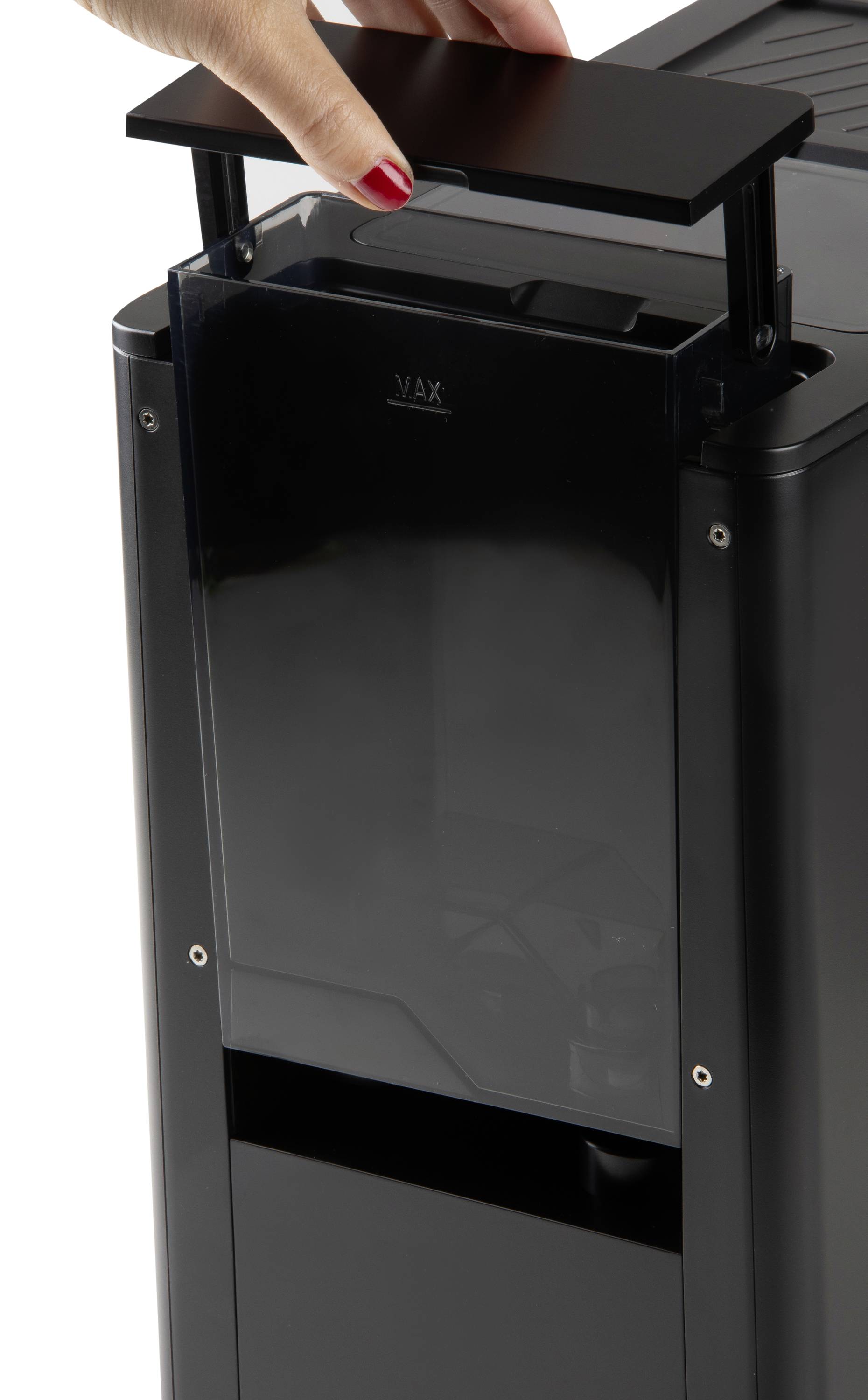 'Zbliżenie dłoni otwierającej górną część nowoczesnego czarnego urządzenia, prawdopodobnie oczyszczacza powietrza lub podobnego sprzętu.'