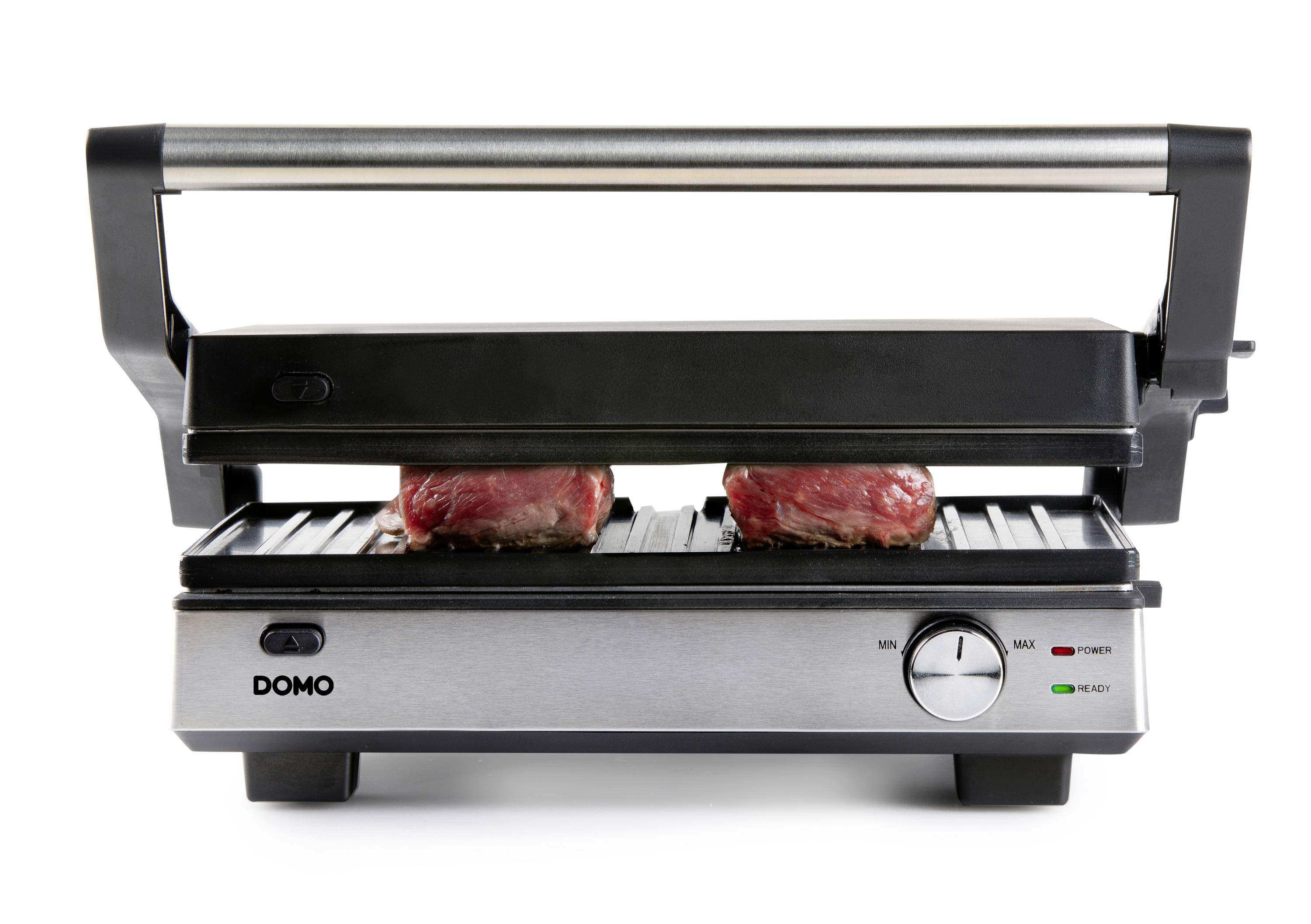 Grill kontaktowy z dwoma kawałkami surowego mięsa na powierzchni grillowej, pod zamkniętą górną płytą grilla.